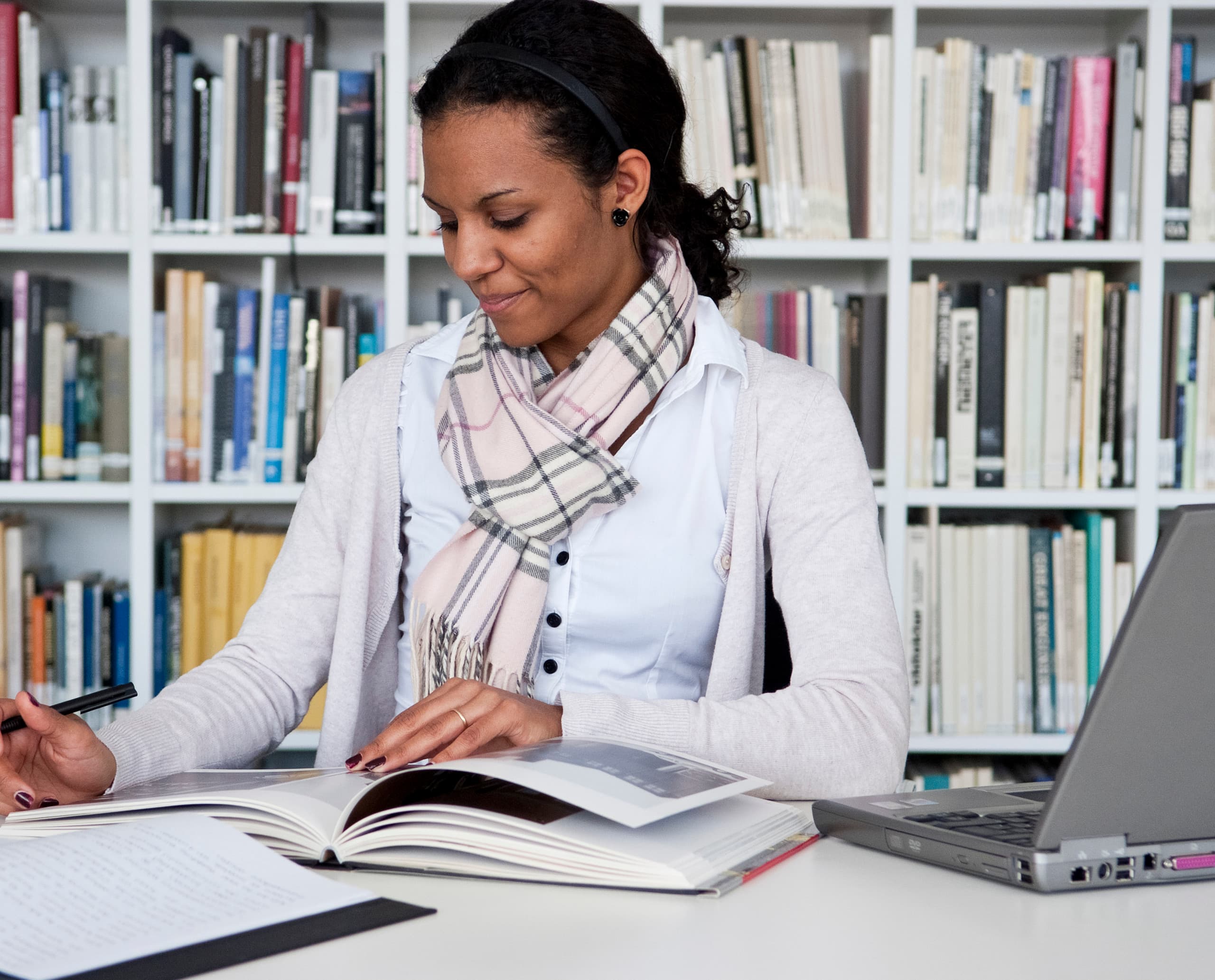 Studentin arbeitet an ihrer Abschlussarbeit in der Bibliothek.