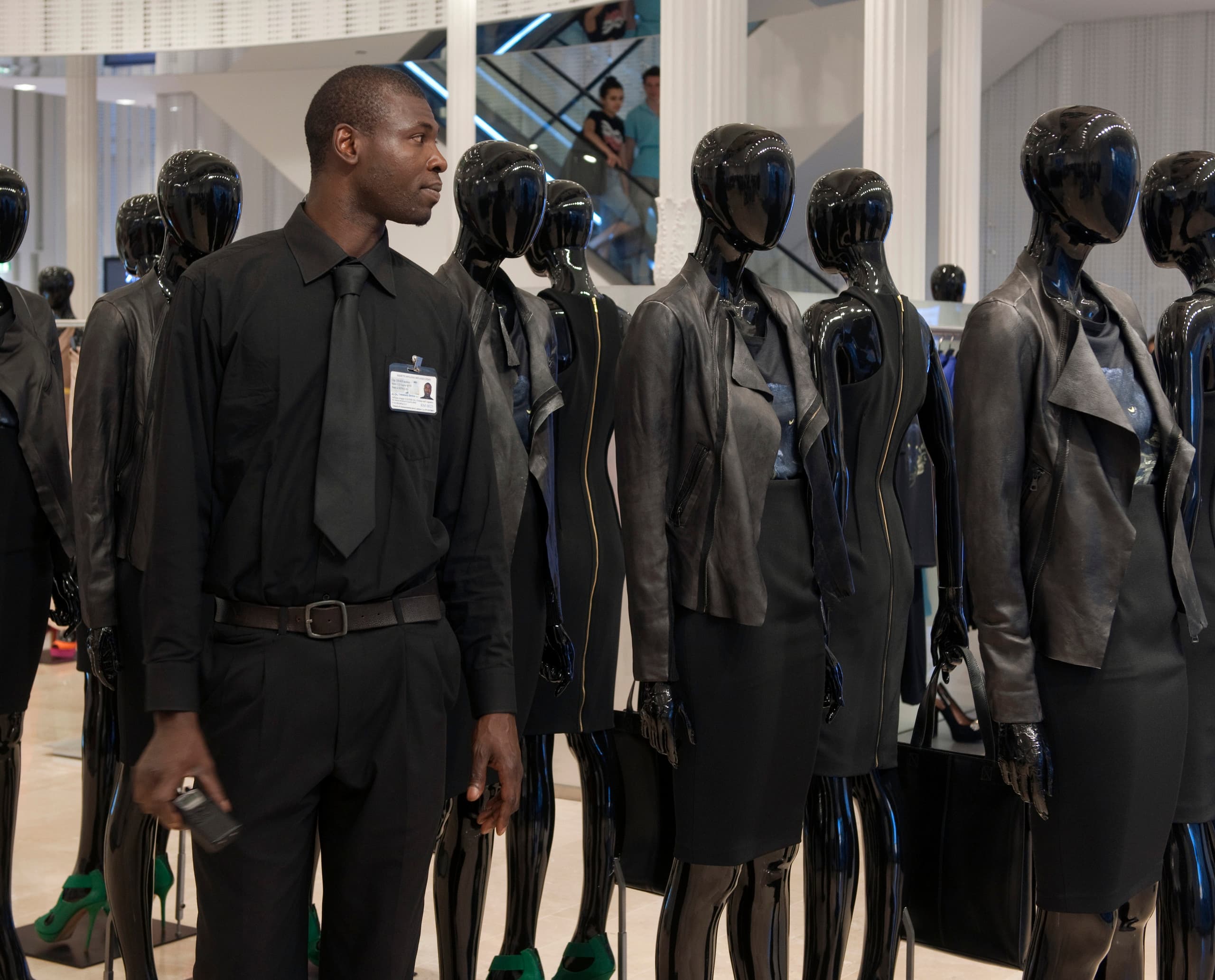 Zara Store-Sicherheitsmann mit Optec Strahlern beleuchteten Schaufensterpuppen, die Mode präsentieren.