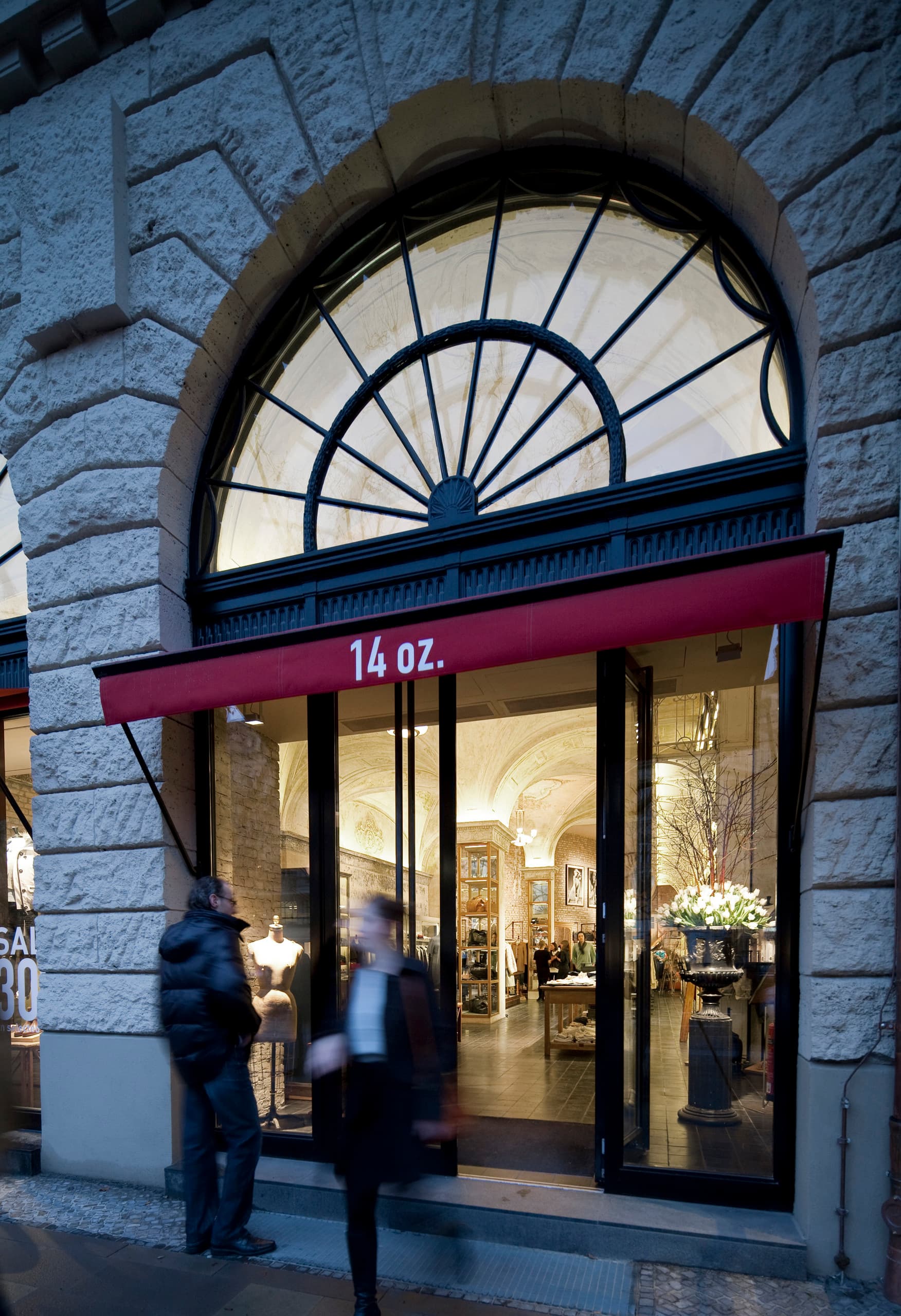 Fassade des 14 oz. Store in Berlin mit einladender Beleuchtung durch ERCO Logotec Strahler.