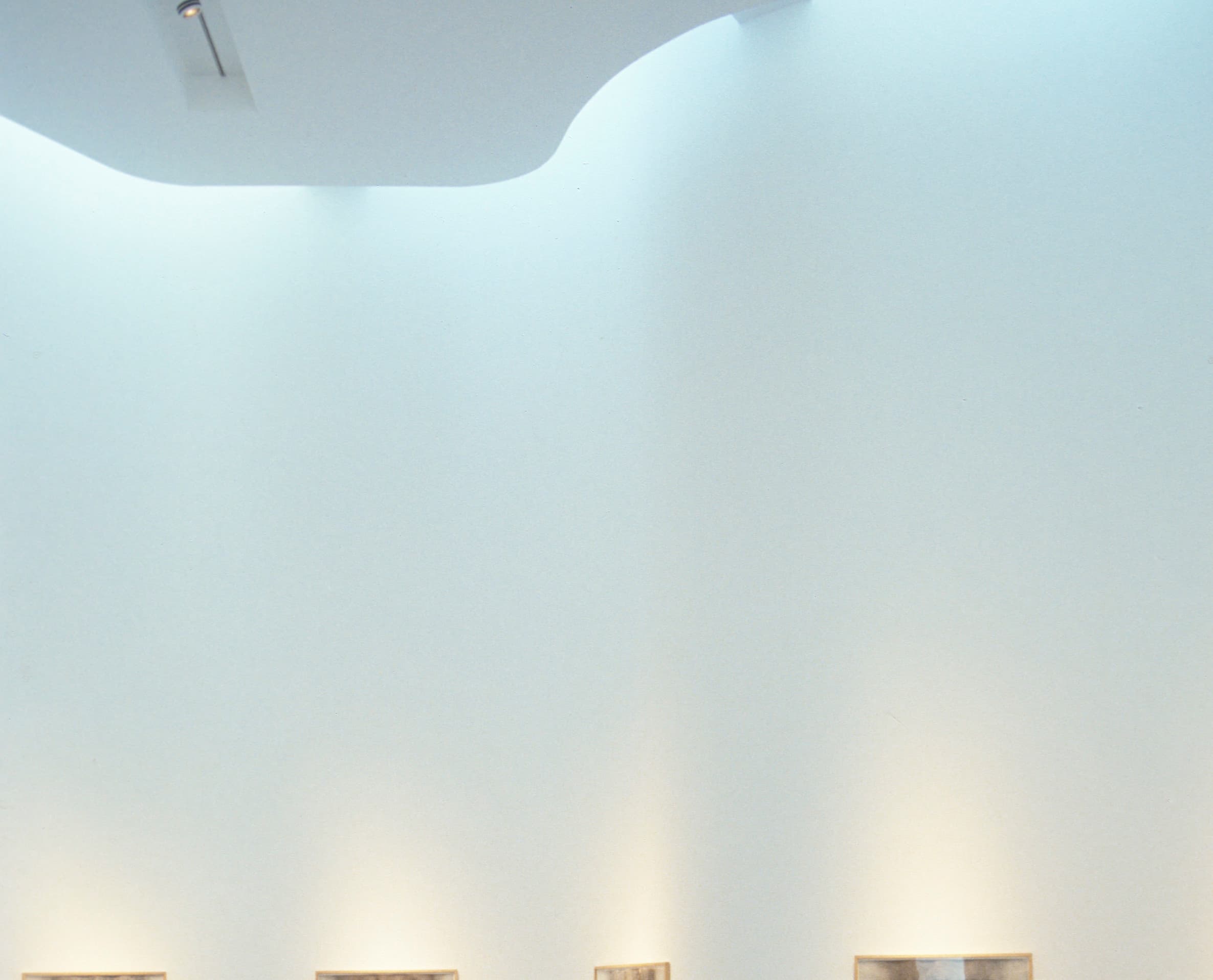 Frau betrachtet Kunstwerke im Louvre-Lens, beleuchtet mit ERCO LED-Lichtern.