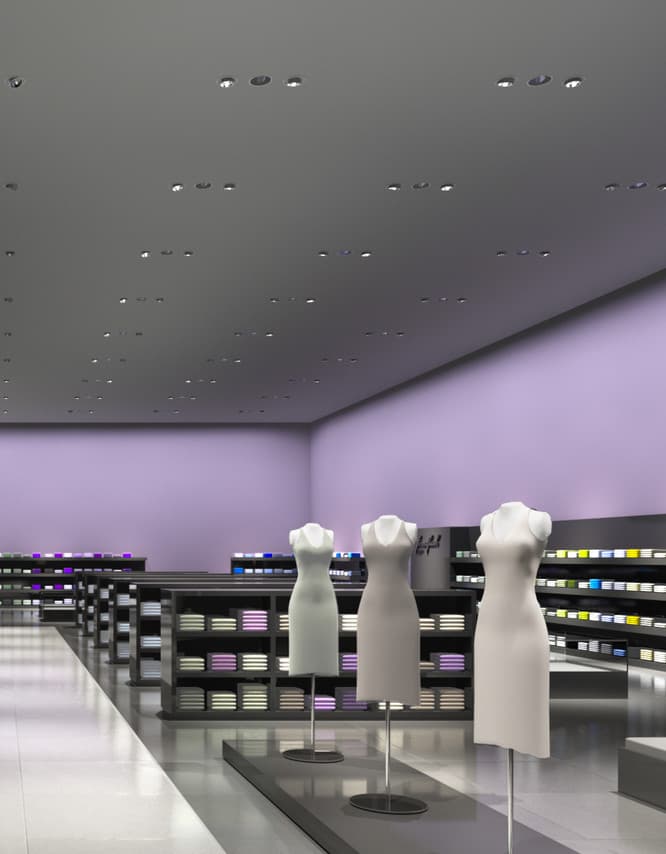Innenraum eines Bekleidungsgeschäfts mit LED-Beleuchtung und Schaufensterpuppen zur Warenpräsentation.