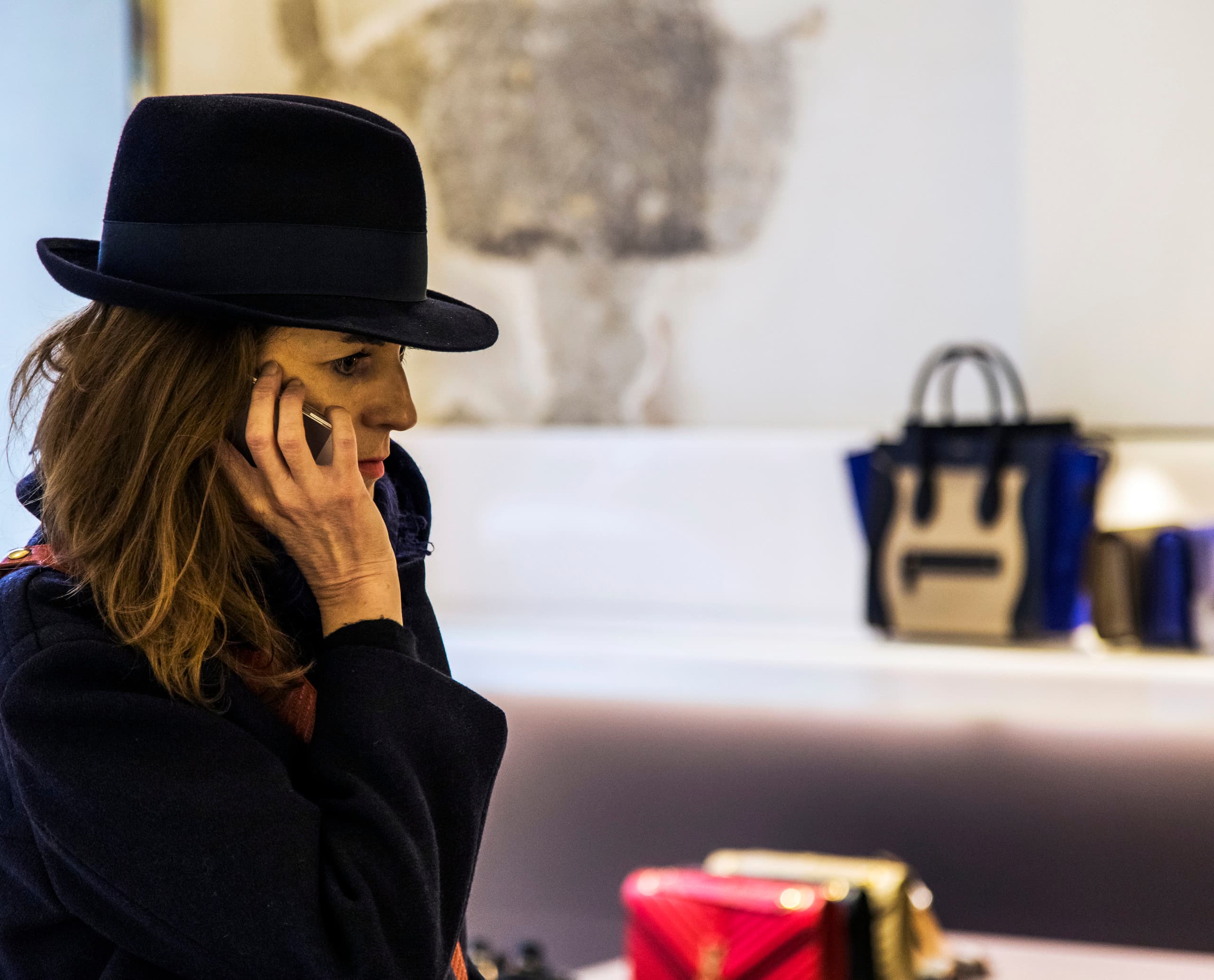 Kundin telefoniert in der Antonia Boutique in Mailand, beleuchtet mit ERCO Optec Strahlern.