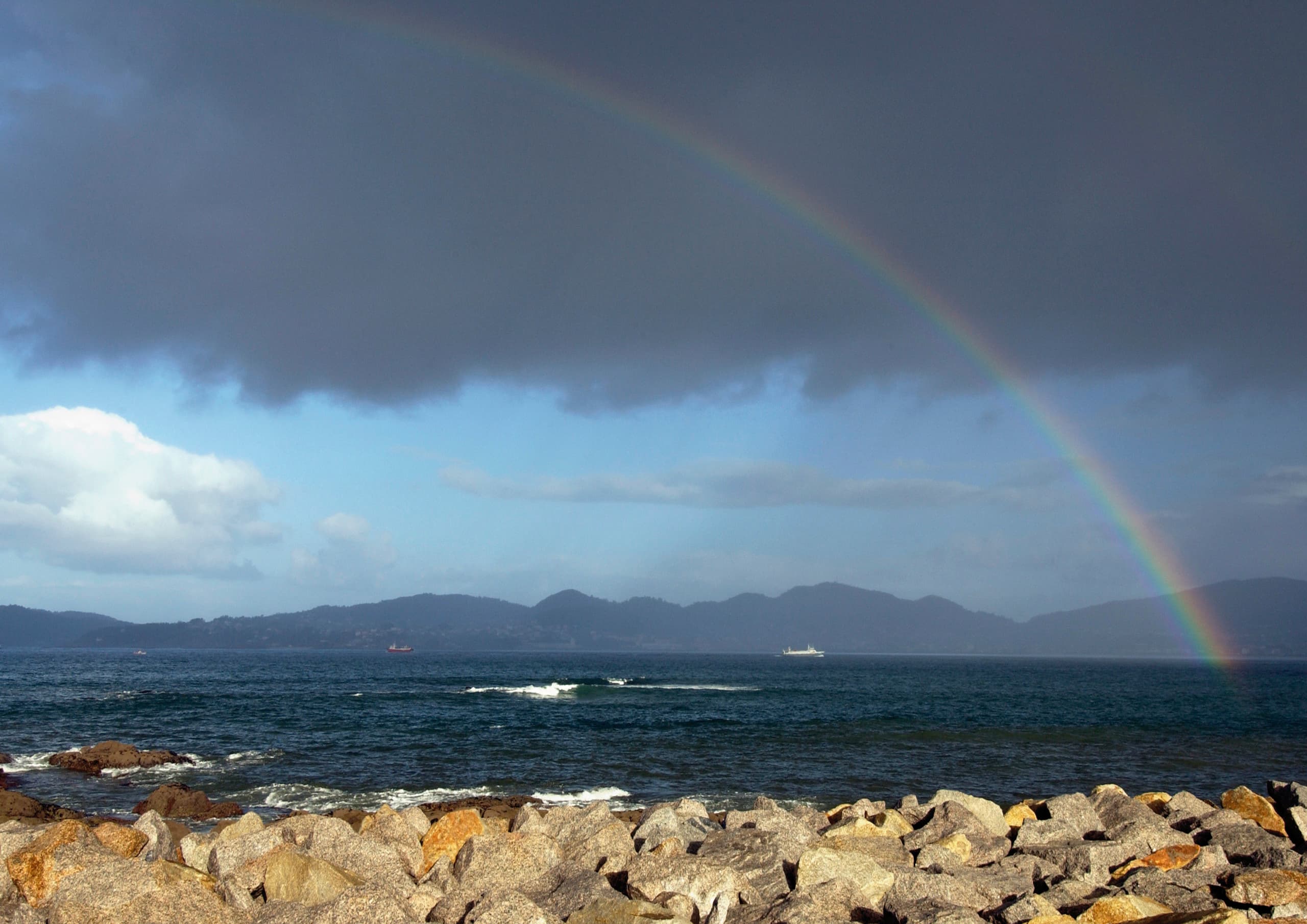 Regenbogen über dem Meer, ein Beispiel für natürliche Lichtphänomene und Orientierung in der Landschaft.
