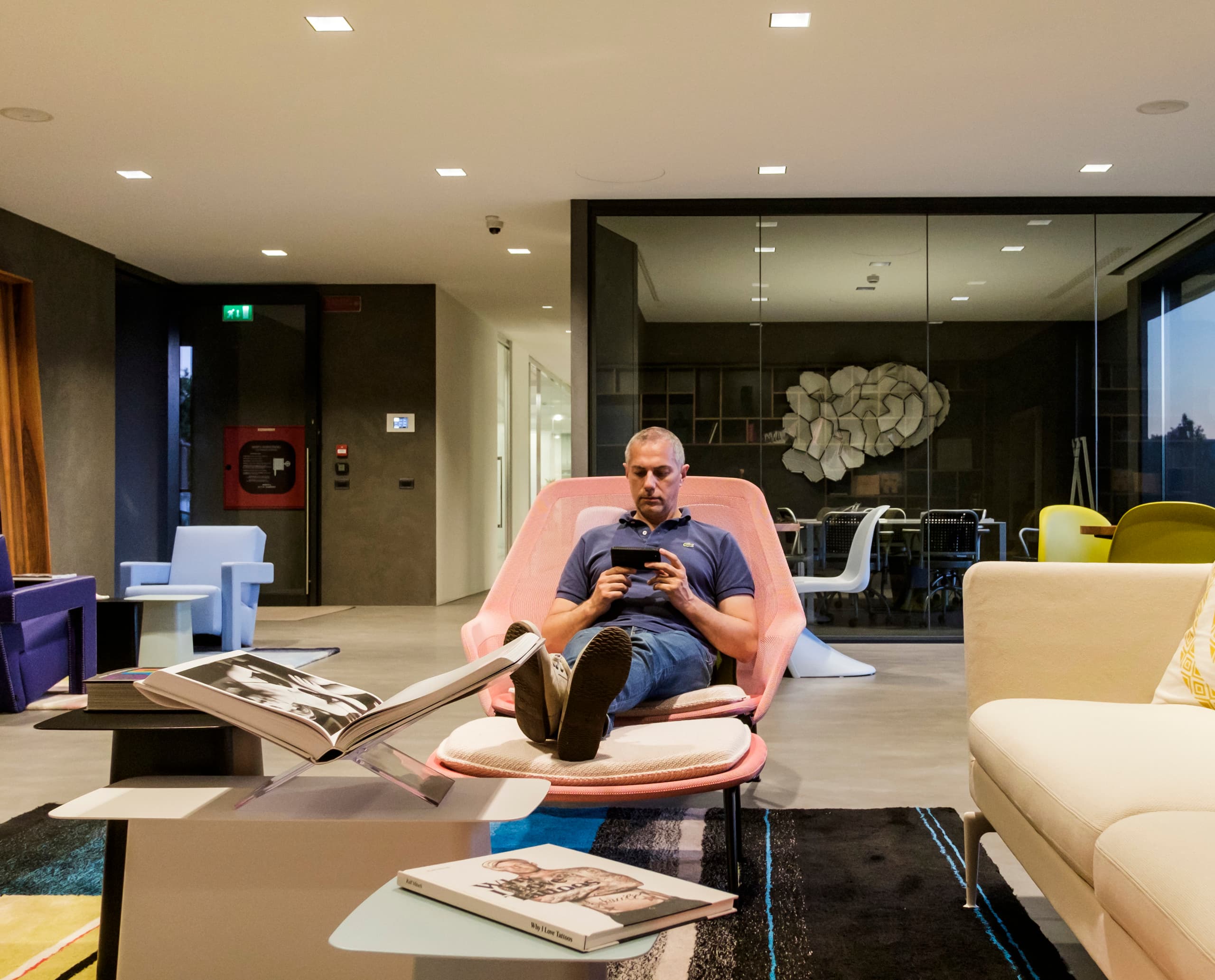 Mann entspannt in Le Silla Zentrale unter ERCO Beleuchtung, modernes Design.