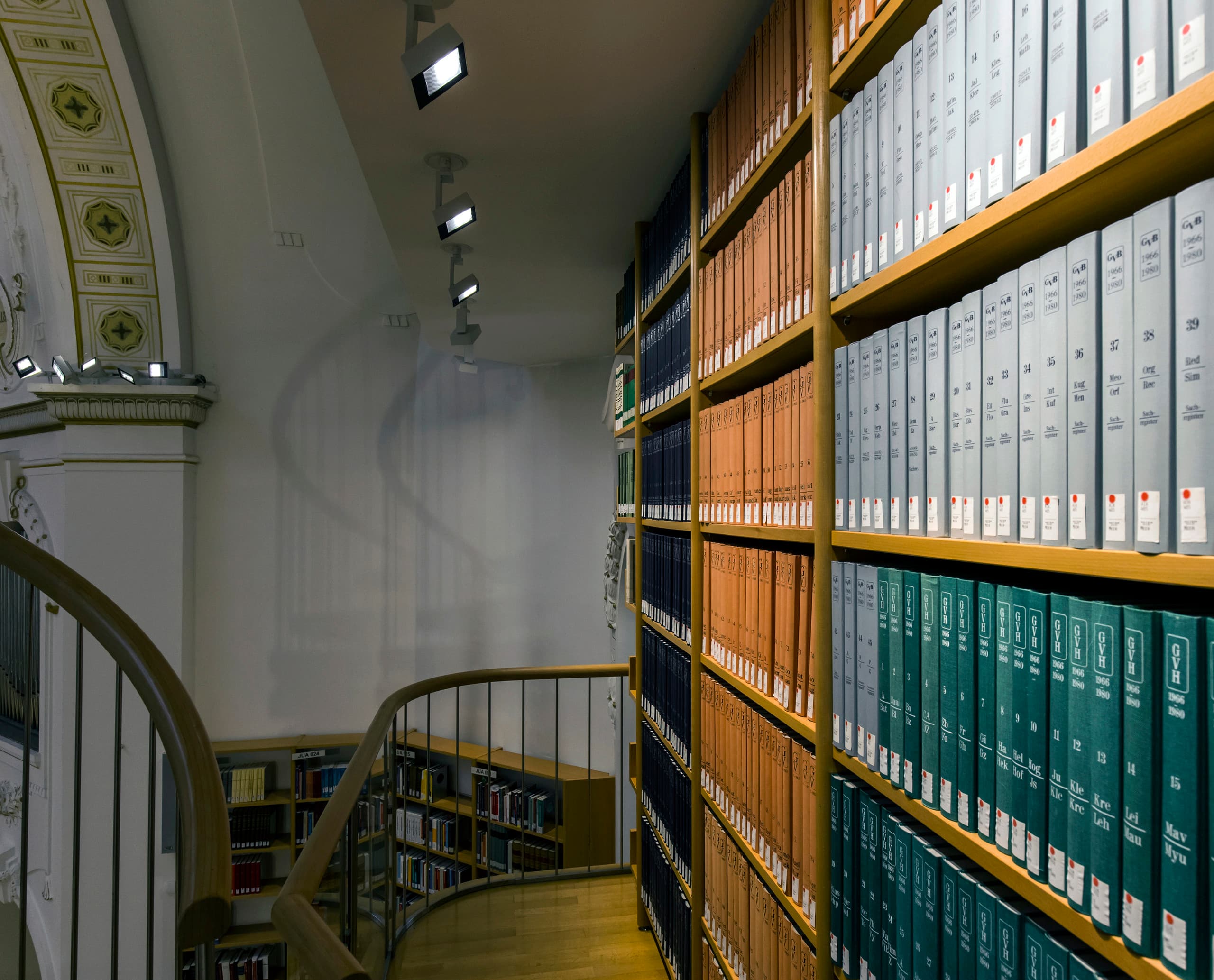 ERCO LED Beleuchtung in der Vorarlberger Landesbibliothek mit Bücherregalen und Wendeltreppe.