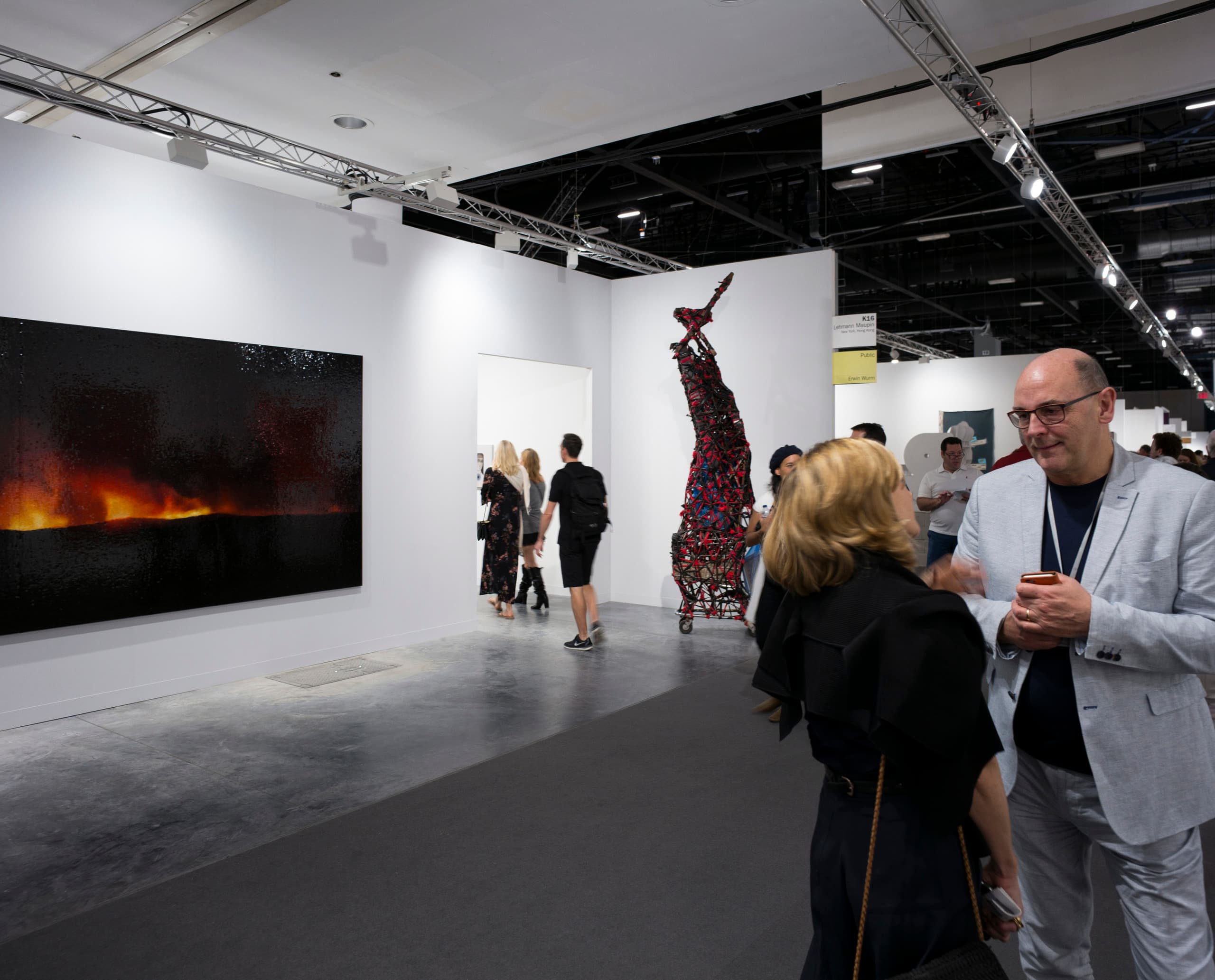 Kunstmesse mit ERCO Beleuchtung: Besucher betrachten Kunstwerke, akzentuiert mit Parscan Strahlern und Pantrac Wallwasher.