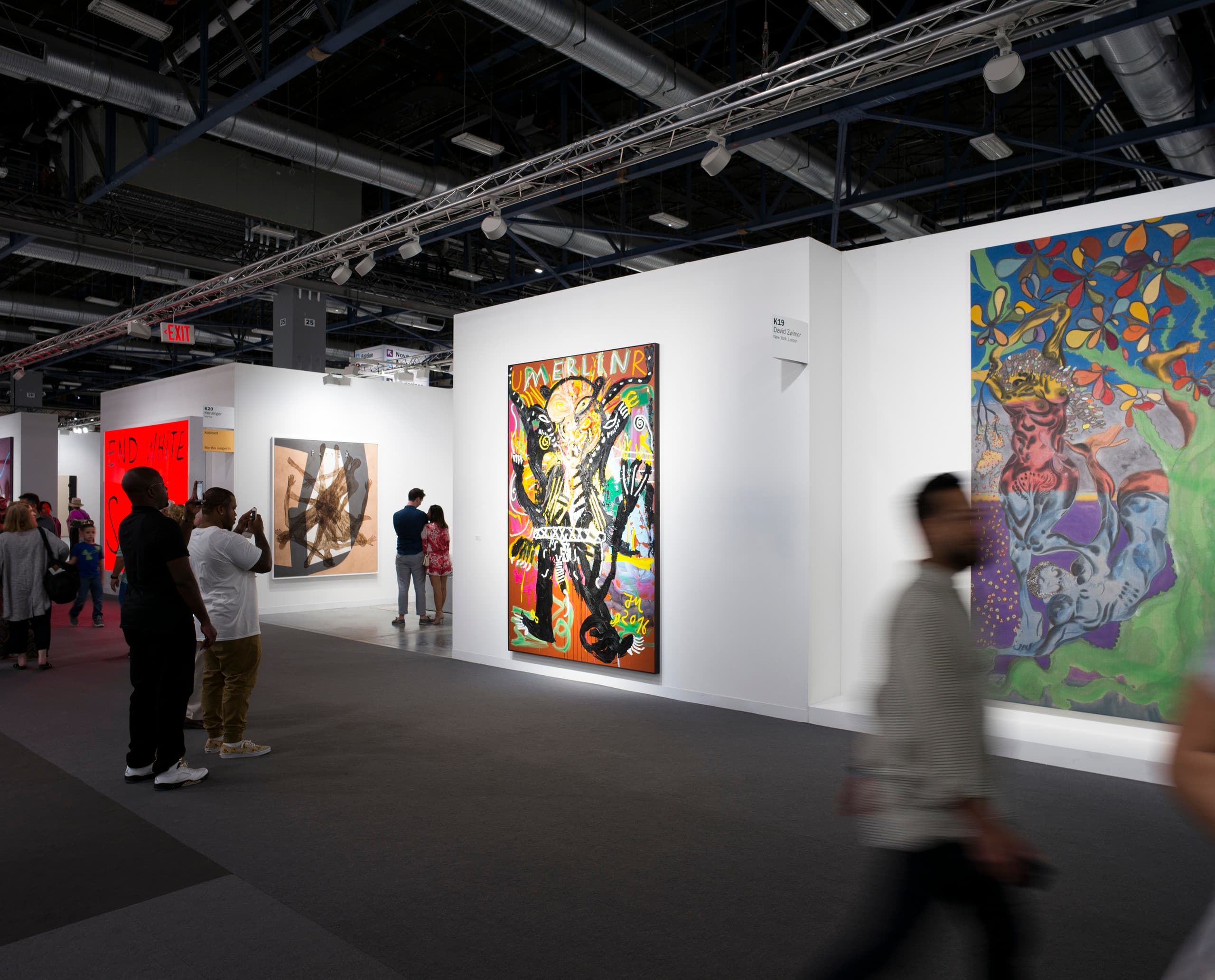 Kunstausstellung mit ERCO Beleuchtung: Besucher betrachten Gemälde auf der Art Basel in Miami.