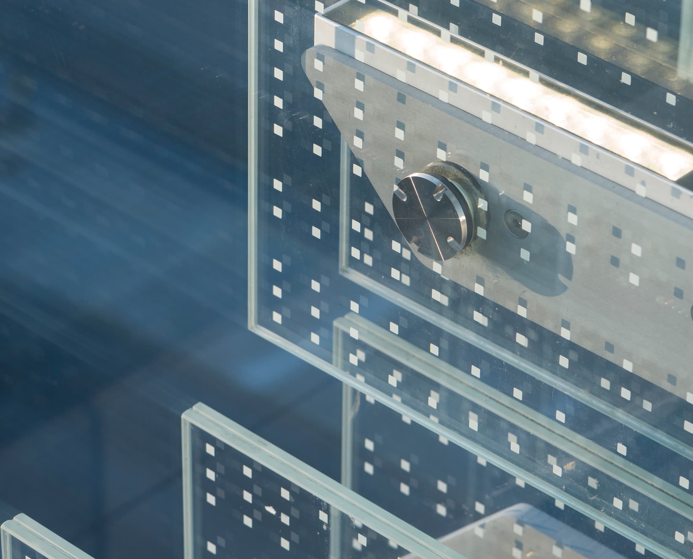 Detailaufnahme der Glaslamellenfassade des SPG Hauptsitzes in Genf, beleuchtet mit ERCO LED Fassadenleuchten.