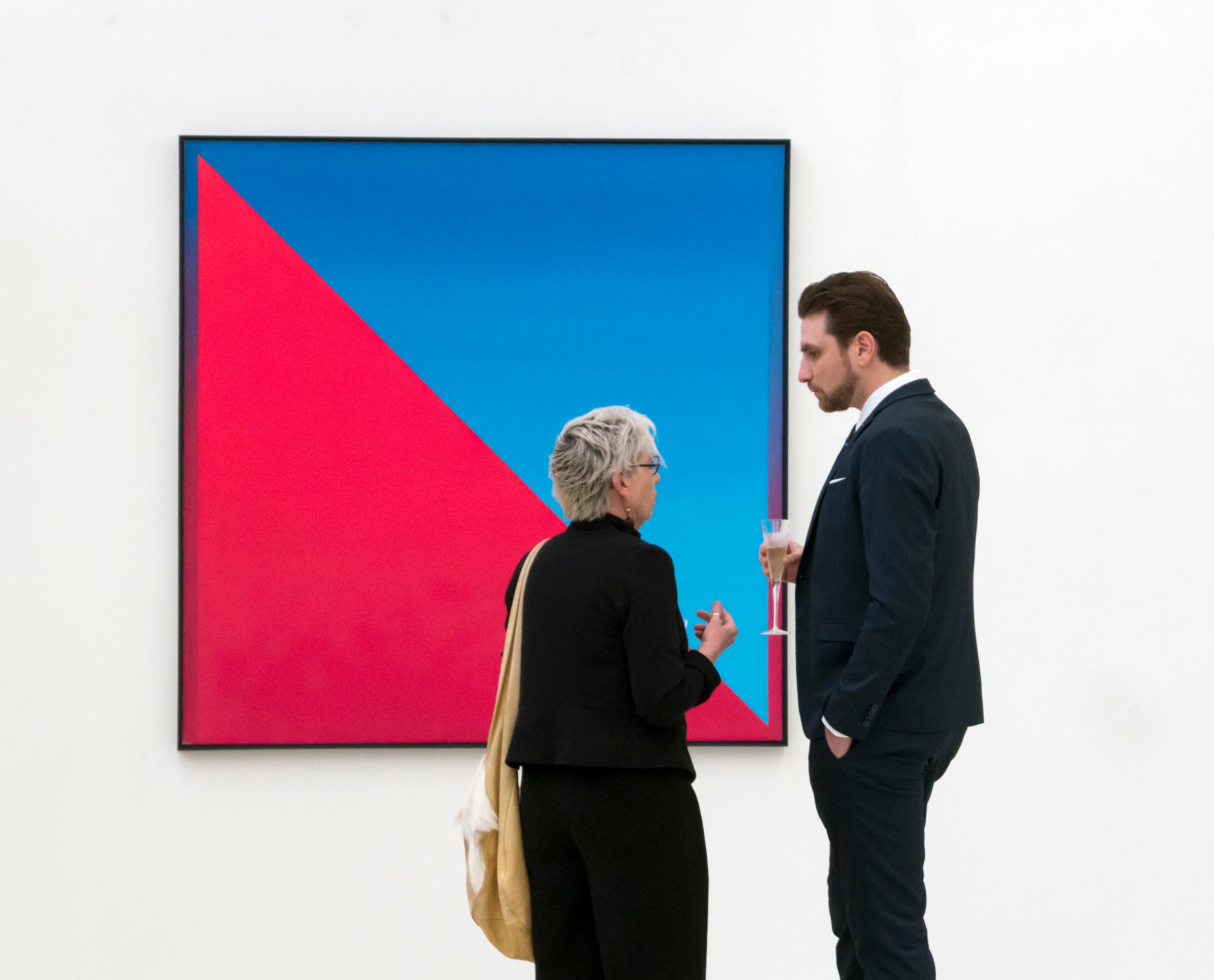 Galeriebesucher betrachten ein abstraktes Kunstwerk unter ERCO-Beleuchtung.