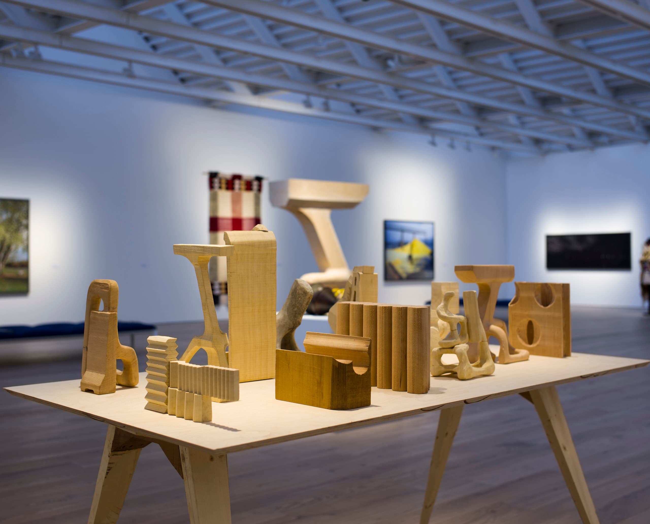 Holzskulpturen auf Tisch in der Polygon Gallery, beleuchtet mit ERCO LED-Strahlern.