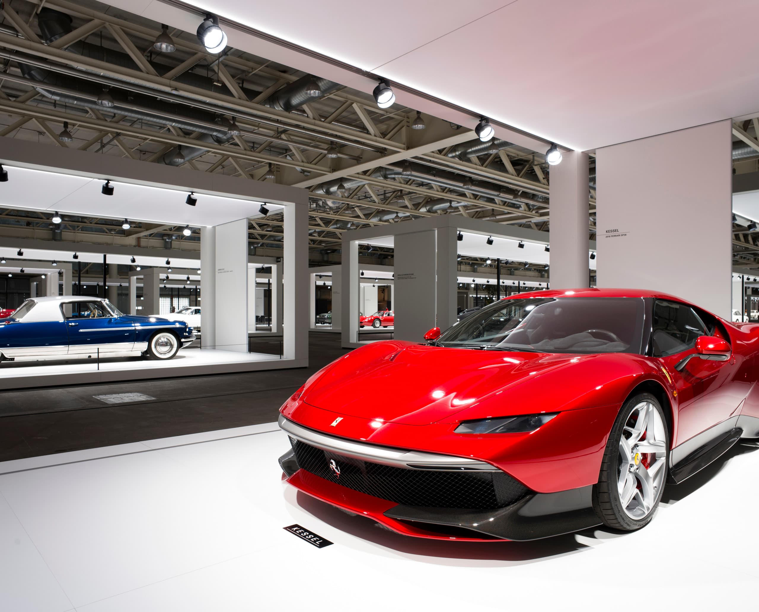 Roter Ferrari Sportwagen auf der Grand Basel Ausstellung, beleuchtet mit ERCO Strahlern.