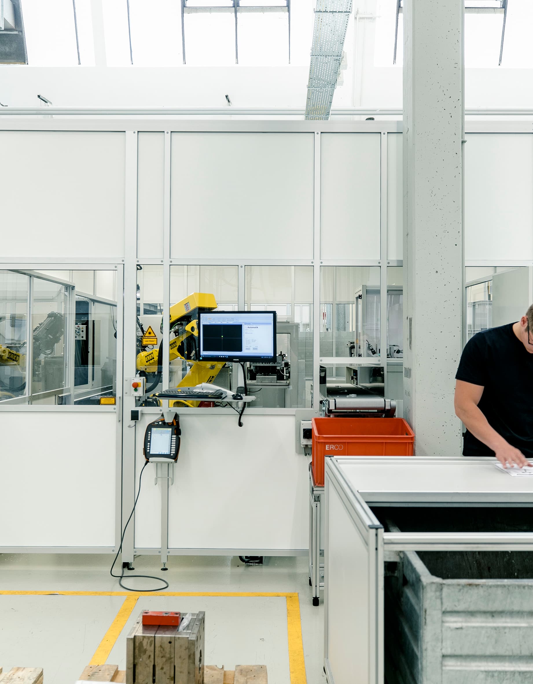 ERCO Mitarbeiter in der Produktion, der Dokumente prüft. Fokus auf Qualität und Präzision im Arbeitsalltag.