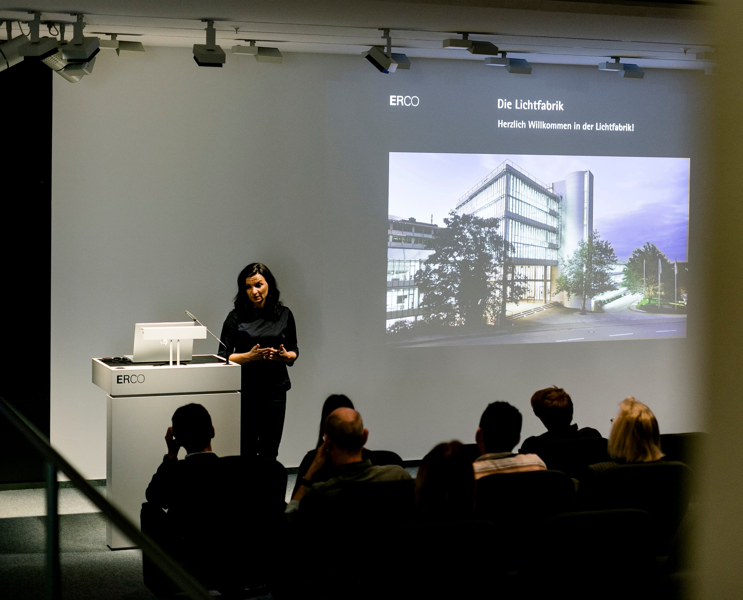 ERCO-Präsentation: Mitarbeiterin spricht über die Lichtfabrik vor Publikum.