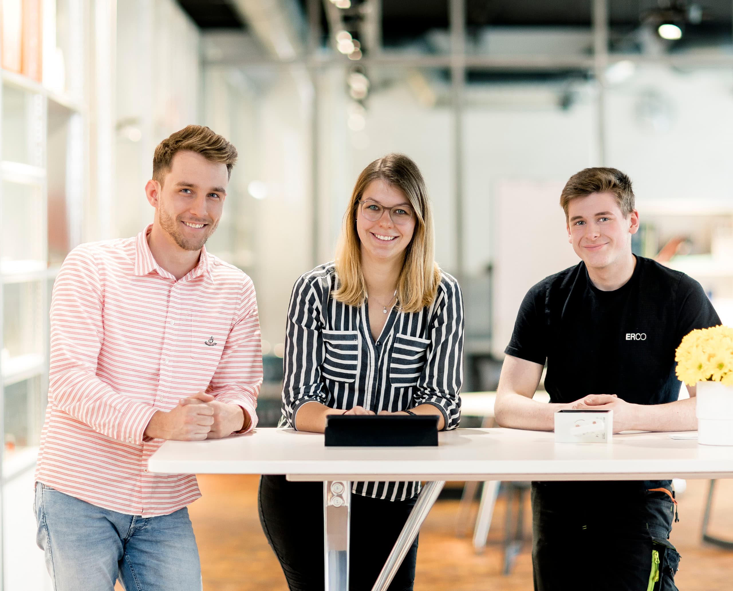 ERCO-Teammitglieder präsentieren sich am Arbeitsplatz, Innovation und Teamgeist.