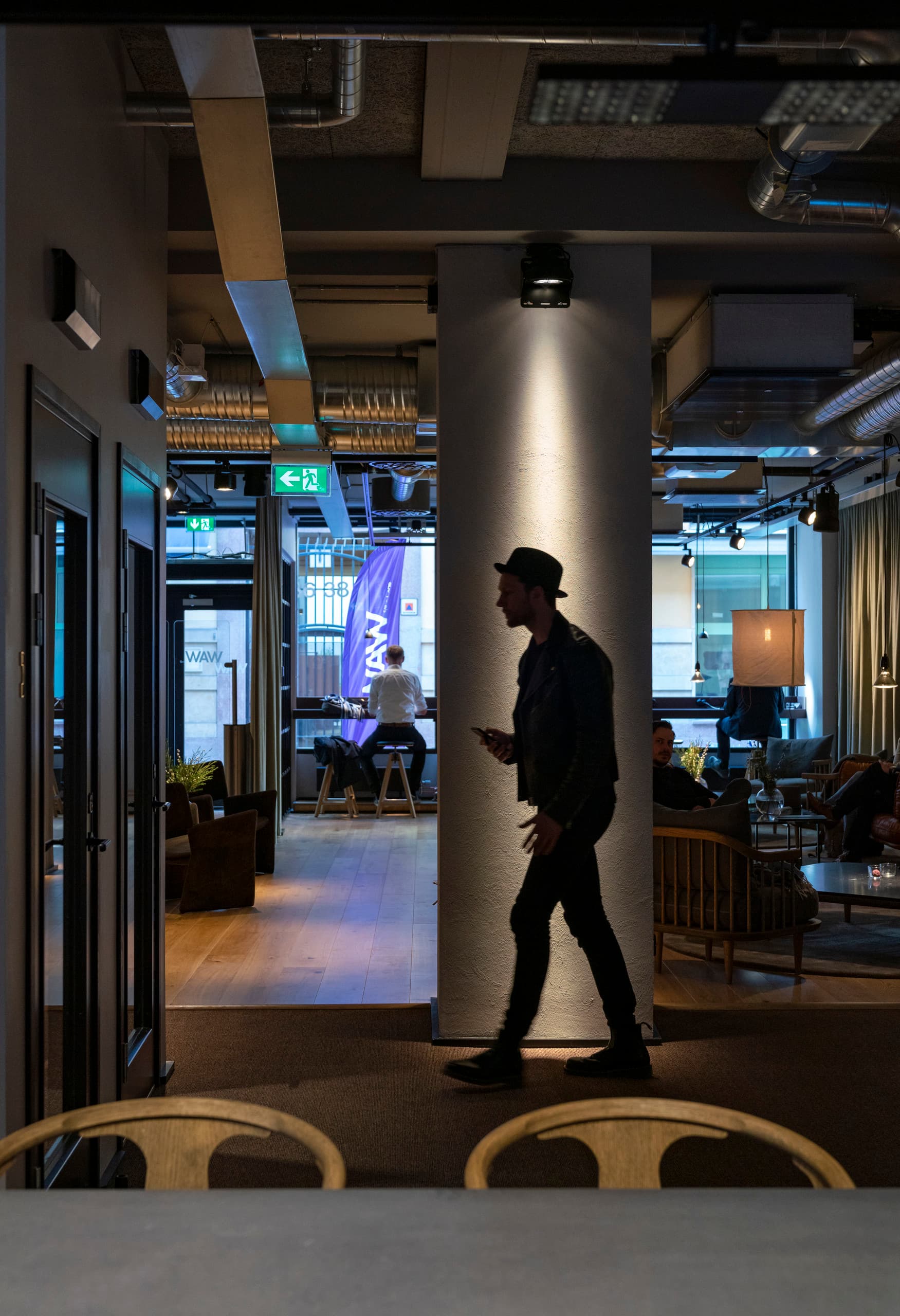 ERCO LED-Spot beleuchtet einen Mann in einem modernen Büro, Teil des Projekts "Work away from Work".