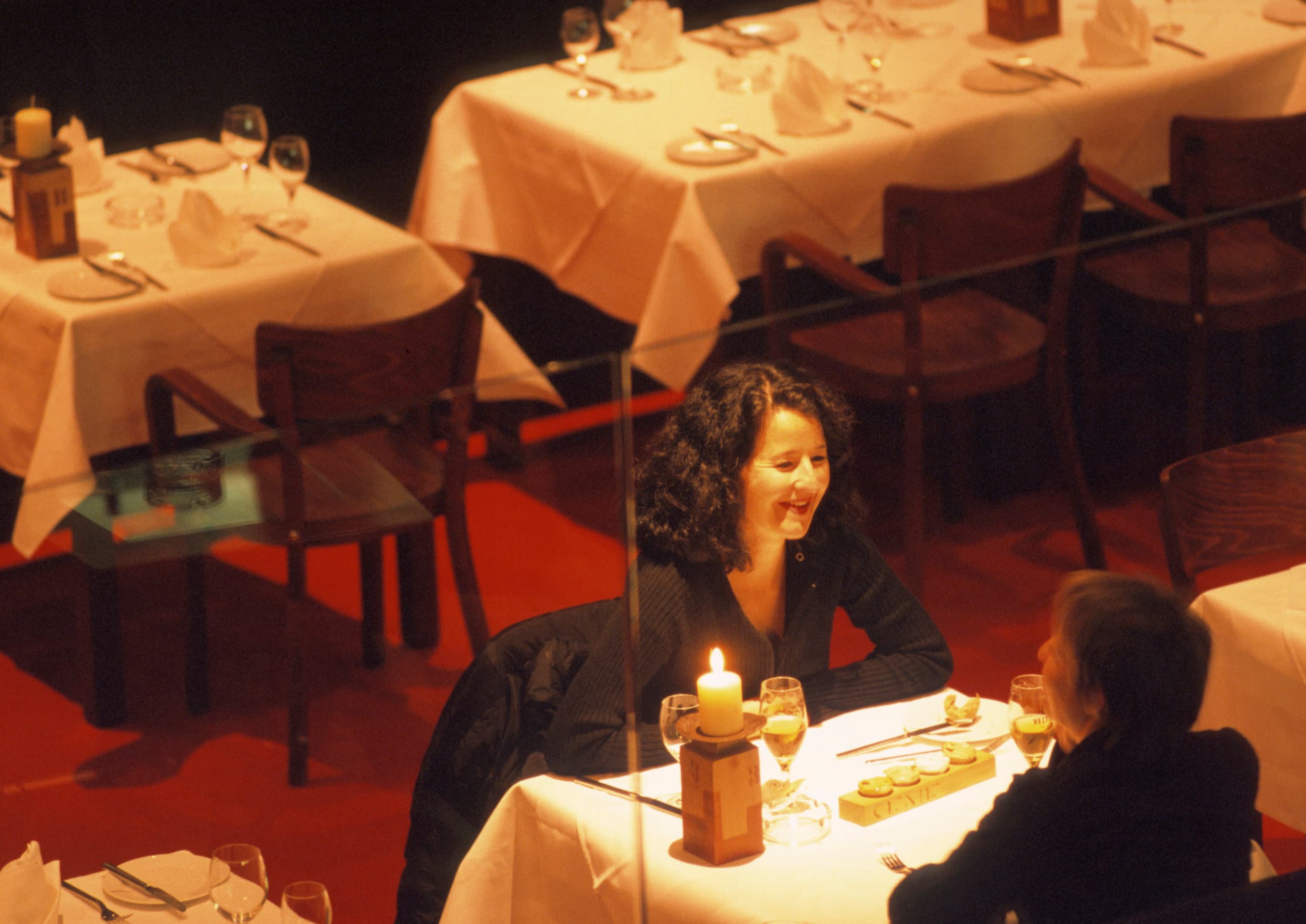 Frau genießt die Lichtstimmung in einem Restaurant, die durch ERCO-Beleuchtung geschaffen wurde.