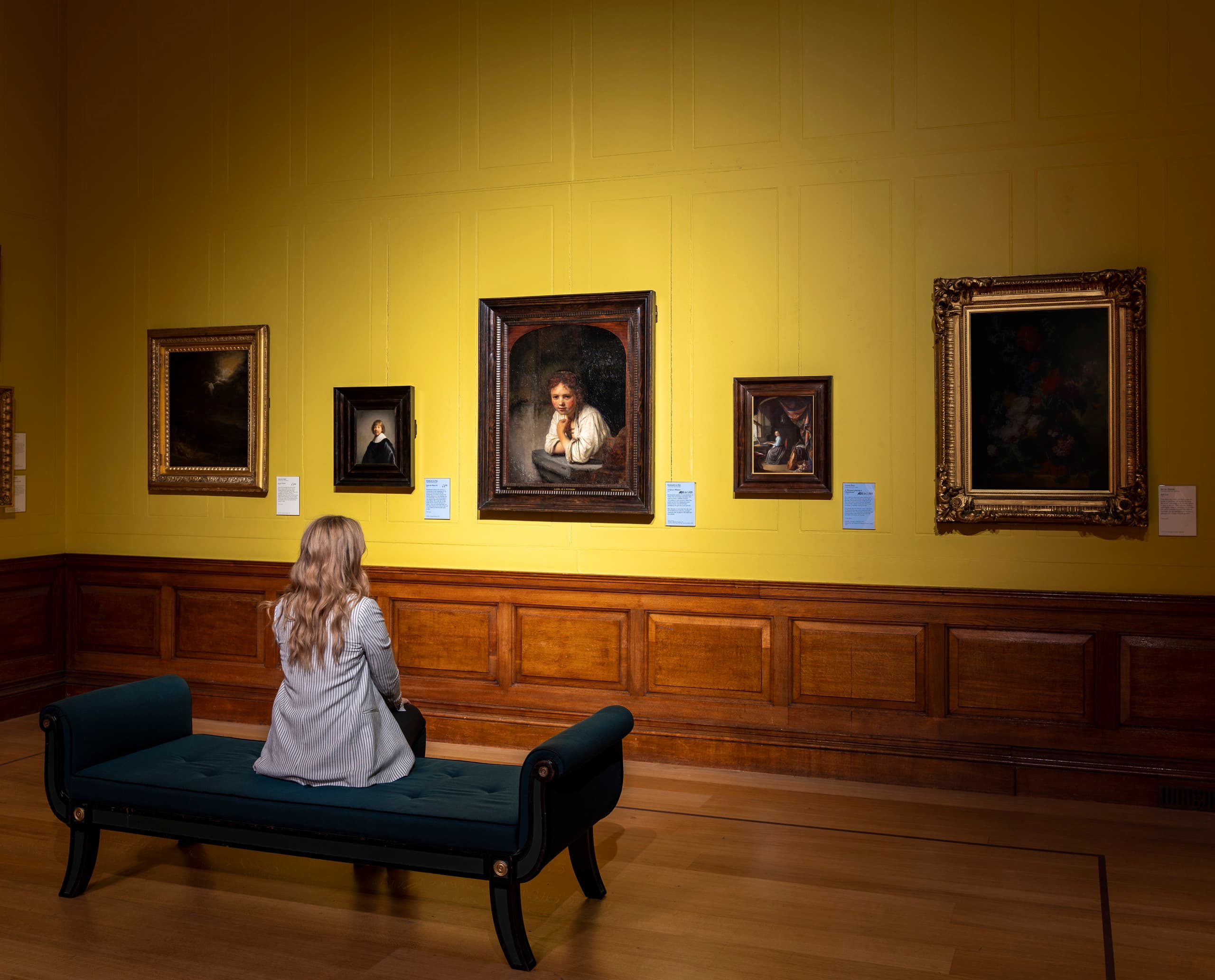 Besucherin betrachtet Rembrandts Gemälde mit ERCO LED-Beleuchtung in der Dulwich Picture Gallery.
