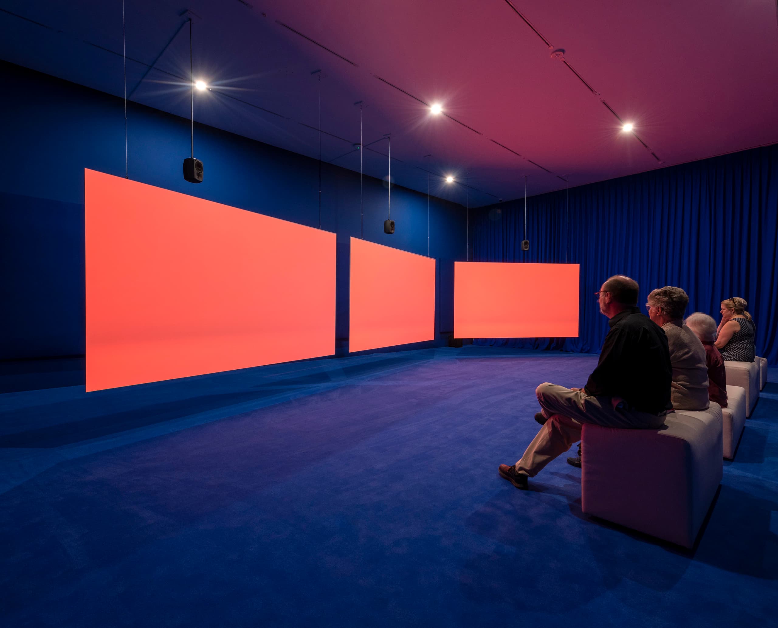 Besucher betrachten Kunstwerke, beleuchtet mit ERCO Parscan Strahlern, in der Ruby City Galerie.