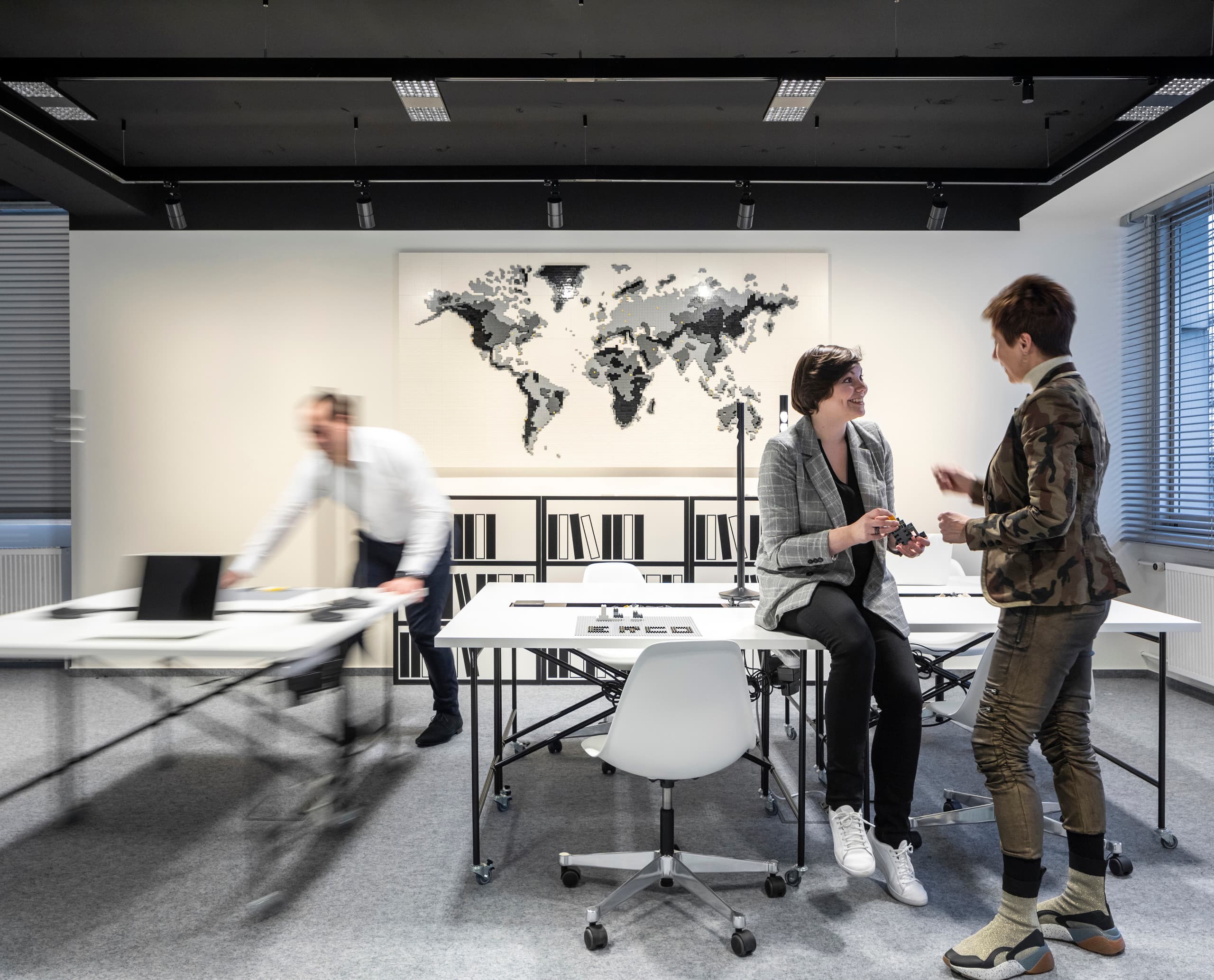 Flexible Bürobeleuchtung mit ERCO Jilly Downlights an einem Stromschienensystem in einem modernen Büro.
