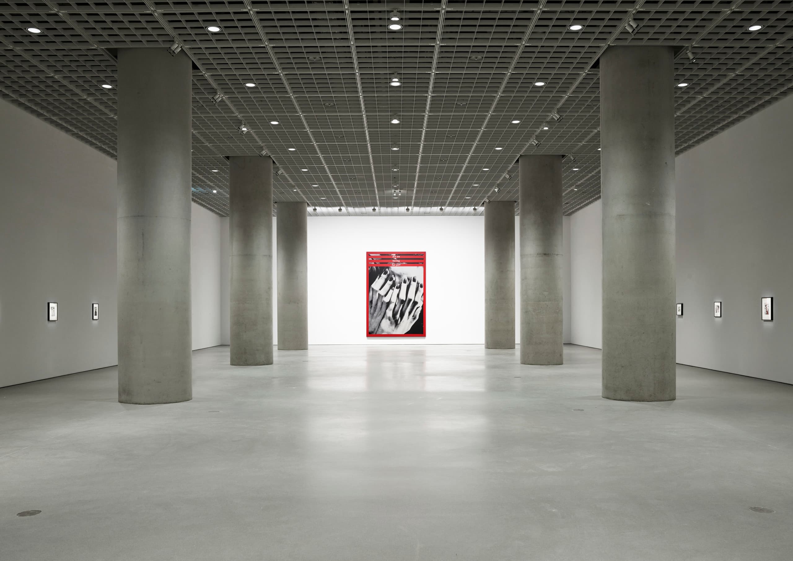 Kunstgalerie mit Betonpfeilern und rotem Kunstwerk, das visuelle Wahrnehmung betont.