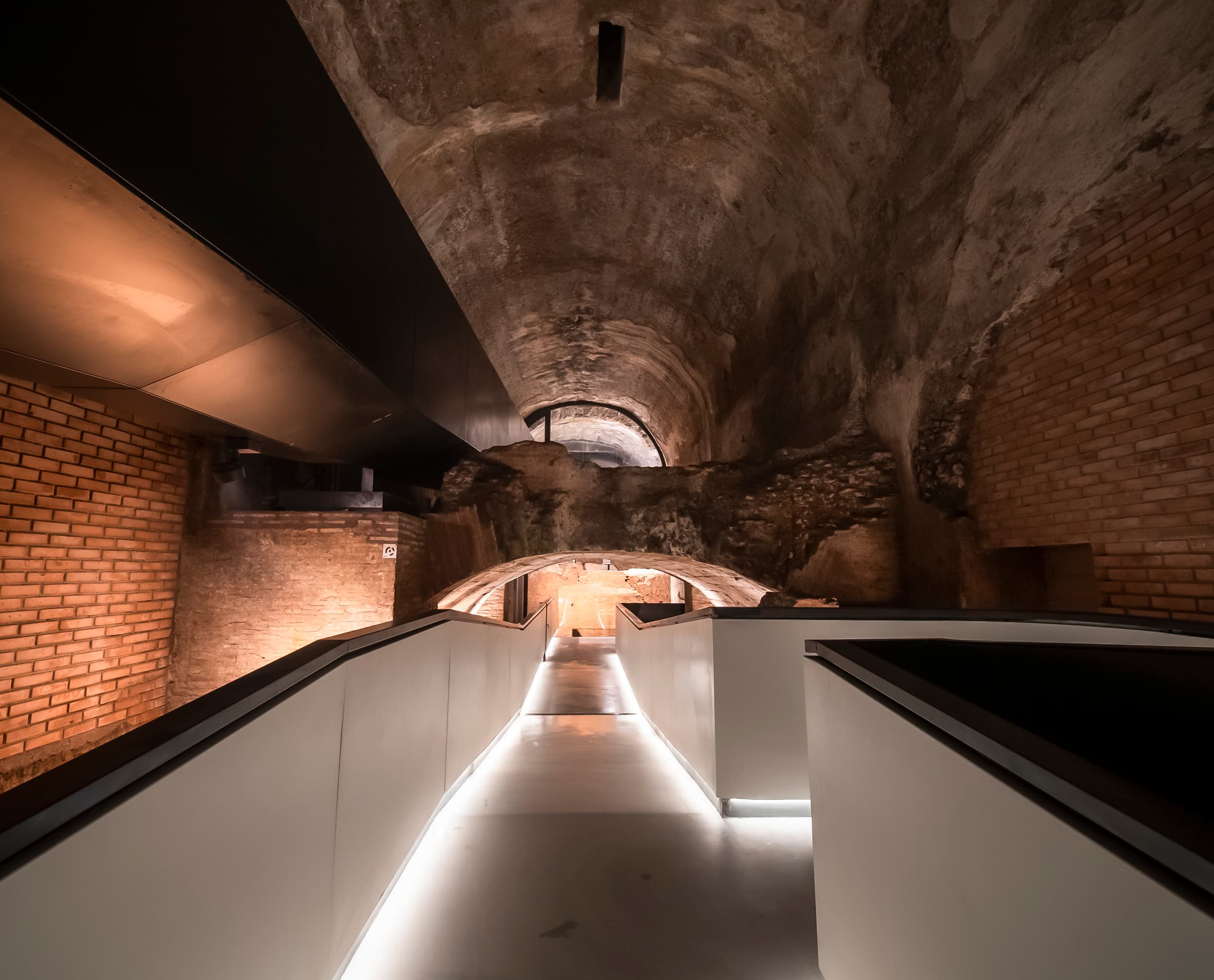 ERCO LED-Beleuchtung im Domus Aurea: Beleuchteter unterirdischer Gang mit antiken Ziegeln und moderner Architektur.