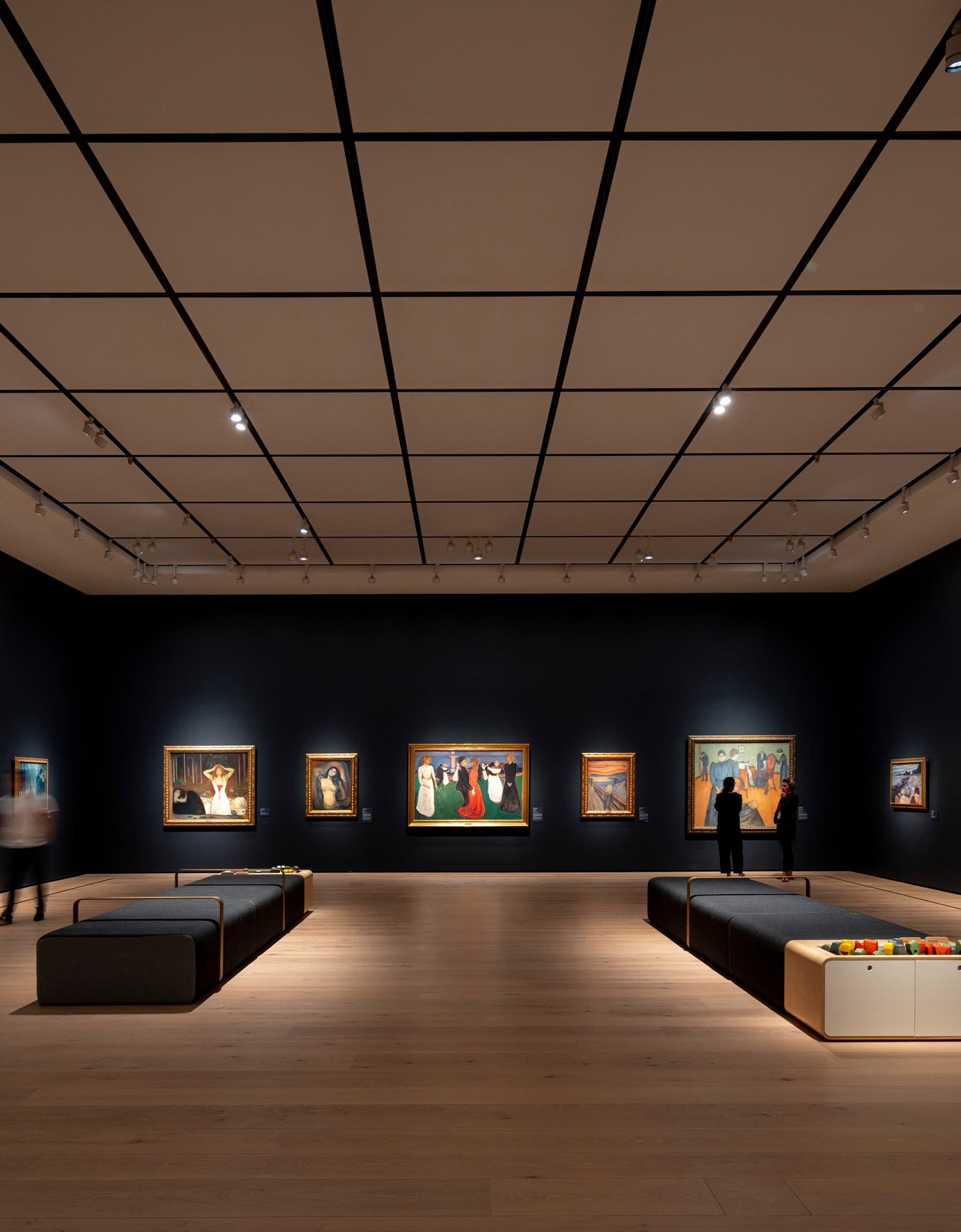 Akzentbeleuchtung in einer Kunstgalerie mit Gemälden, die mit Strahlern hervorgehoben werden.