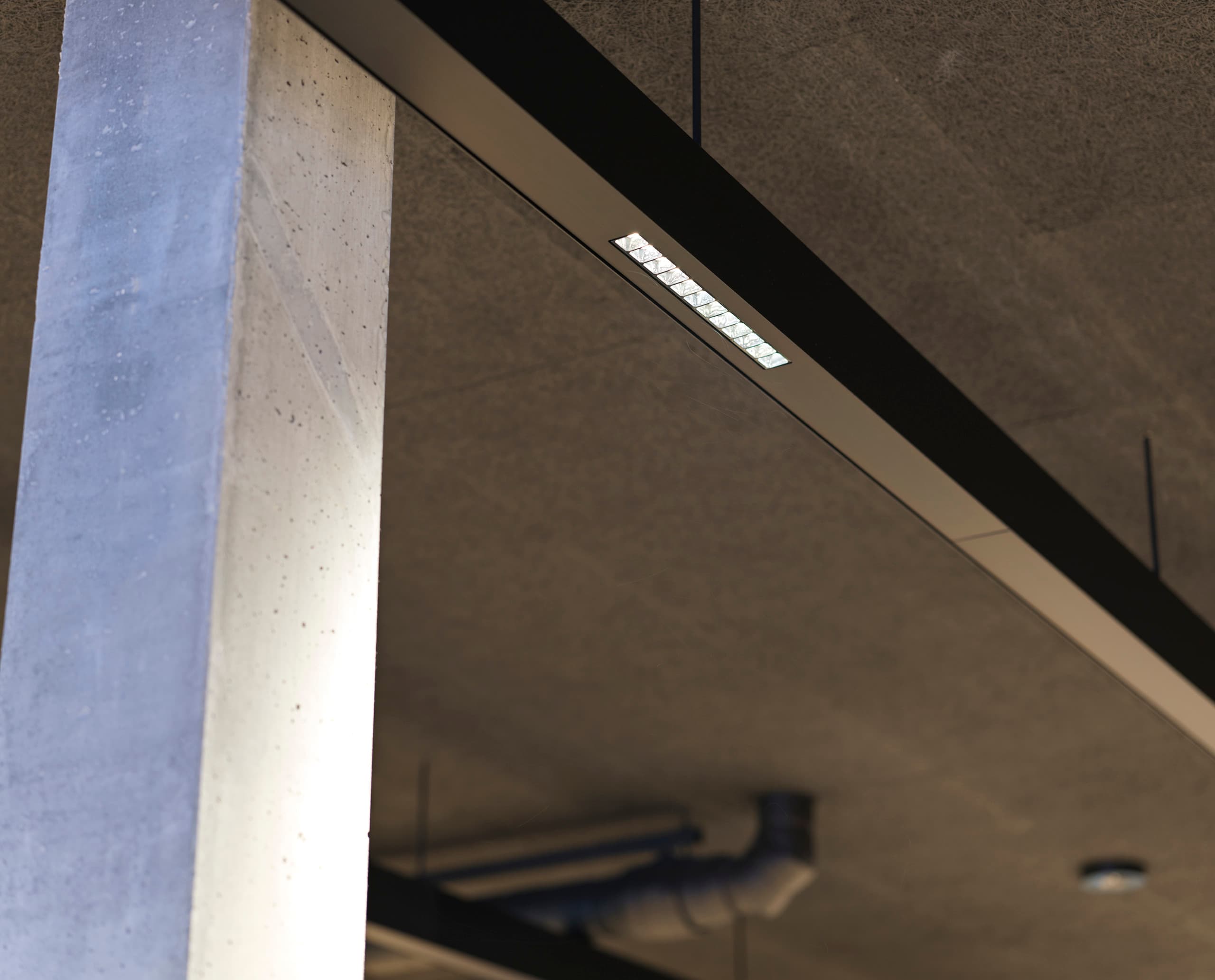 ERCO Compar lineare Downlights in einem Stadion, die blendfreies Licht für hohen Sehkomfort bieten.