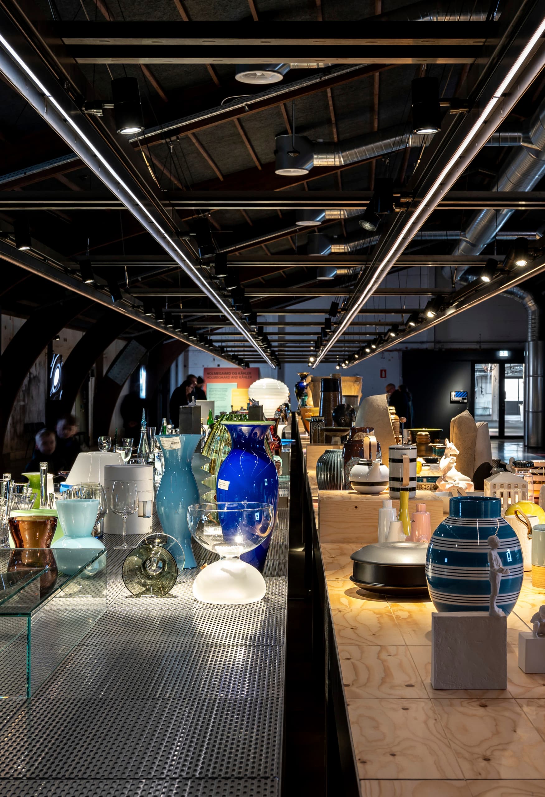 Holmegaard Værk Glasmuseum: Glasobjekte auf Tischen, beleuchtet mit ERCO LED-Strahlern in Dänemark.