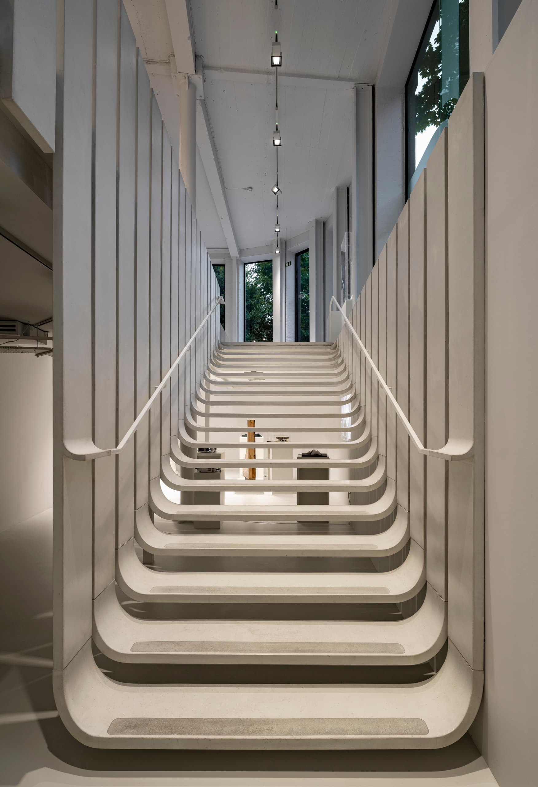 Treppenhaus mit ERCO Beleuchtung im Zaha Hadid Büro London. Modernes Design mit Fokus auf Mitarbeiterwohlbefinden.