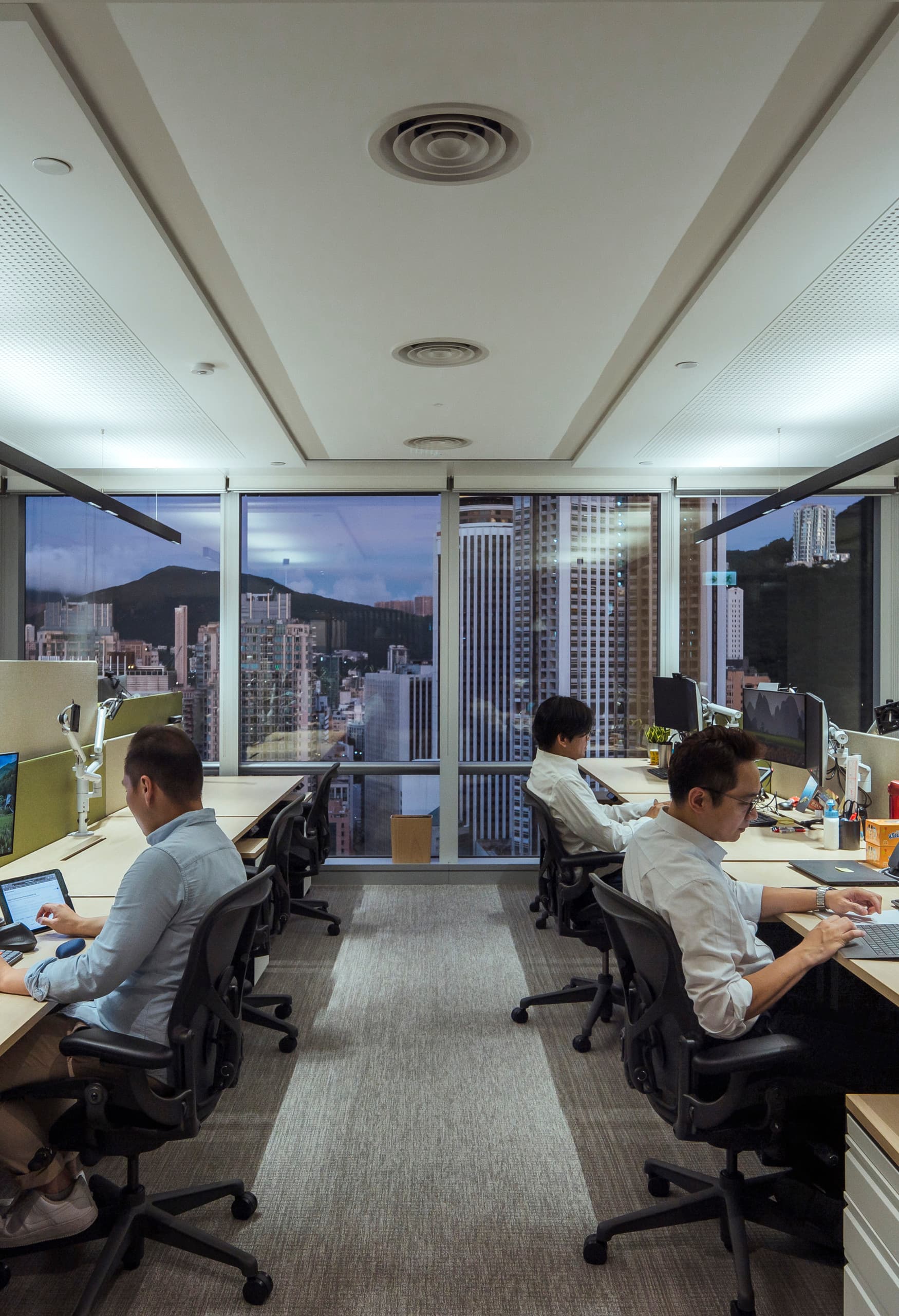 PAG Büro Hong Kong mit Compar Pendelleuchten für visuellen Komfort am Arbeitsplatz.