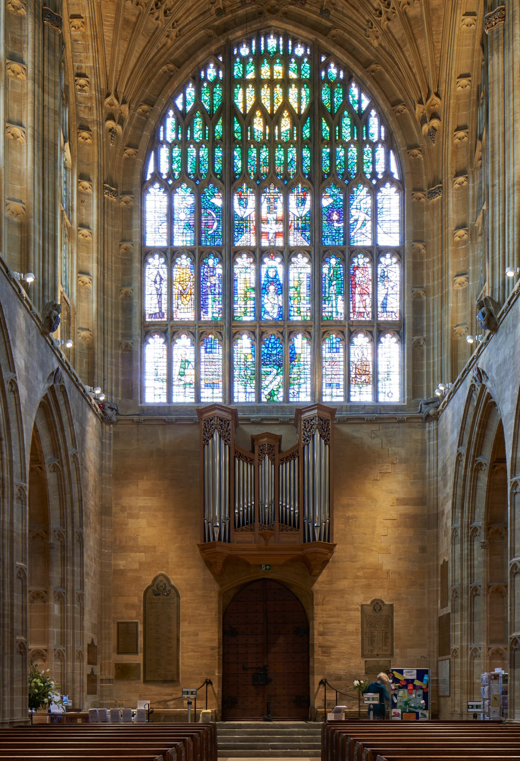 Innenansicht der Sherborne Abbey mit Buntglasfenster und Orgel, beleuchtet mit ERCO LED-Leuchten.