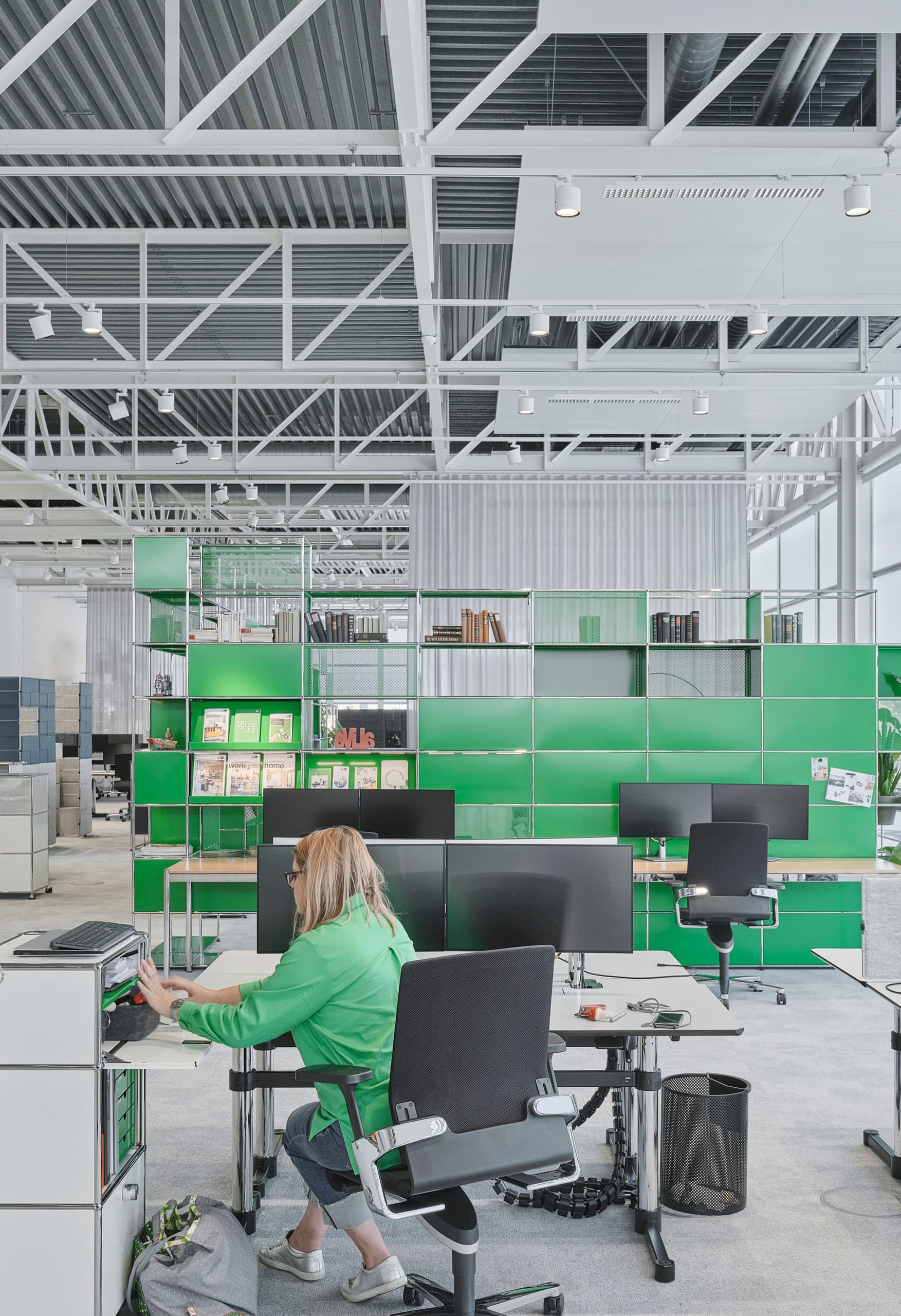 Flexibles ERCO-Lichtdesign im USM Show Office mit Jilly Downlights und Parscan Strahlern für anpassbare Bürobeleuchtung.