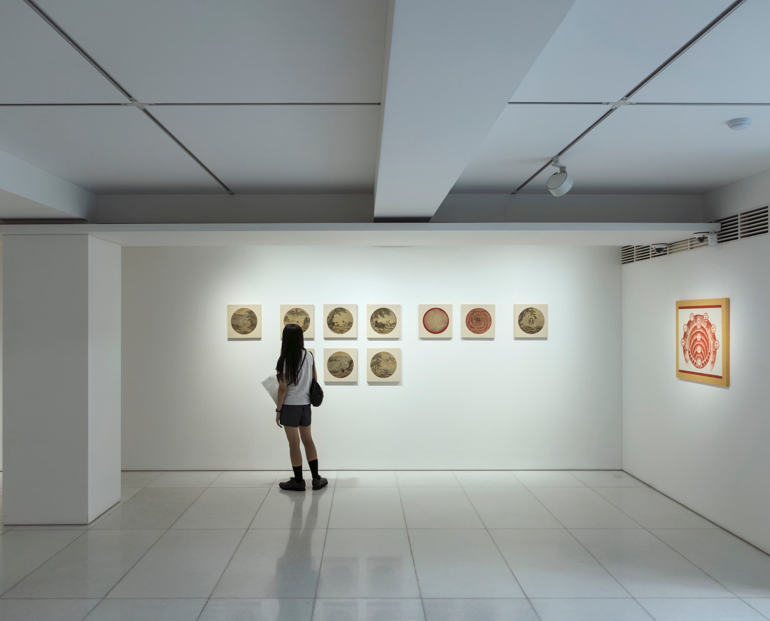 Besucher betrachtet Kunstwerke in der Arario Galerie, beleuchtet mit ERCO Strahlern.