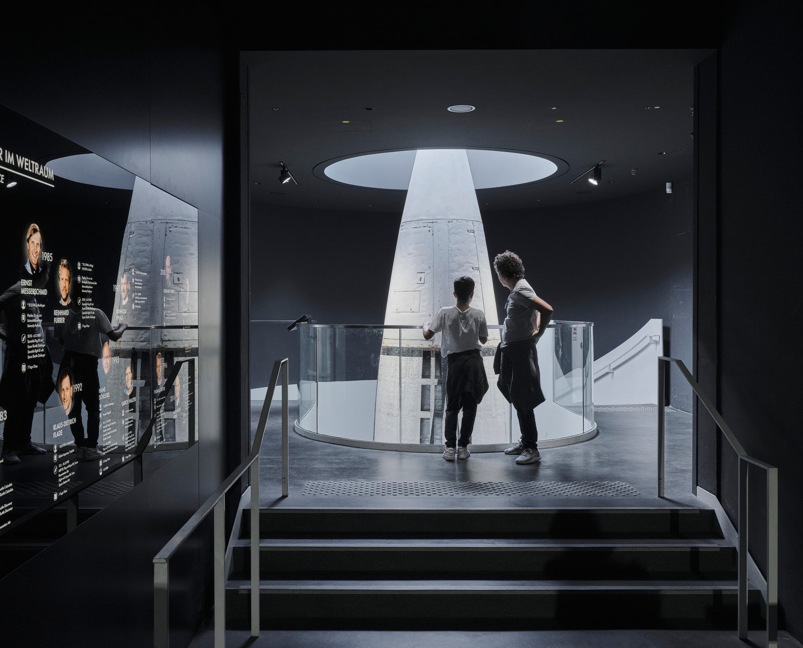 Besucher betrachten eine Rakete im Deutschen Museum, beleuchtet mit ERCO LED Strahlern für ein einheitliches Lichtkonzept.