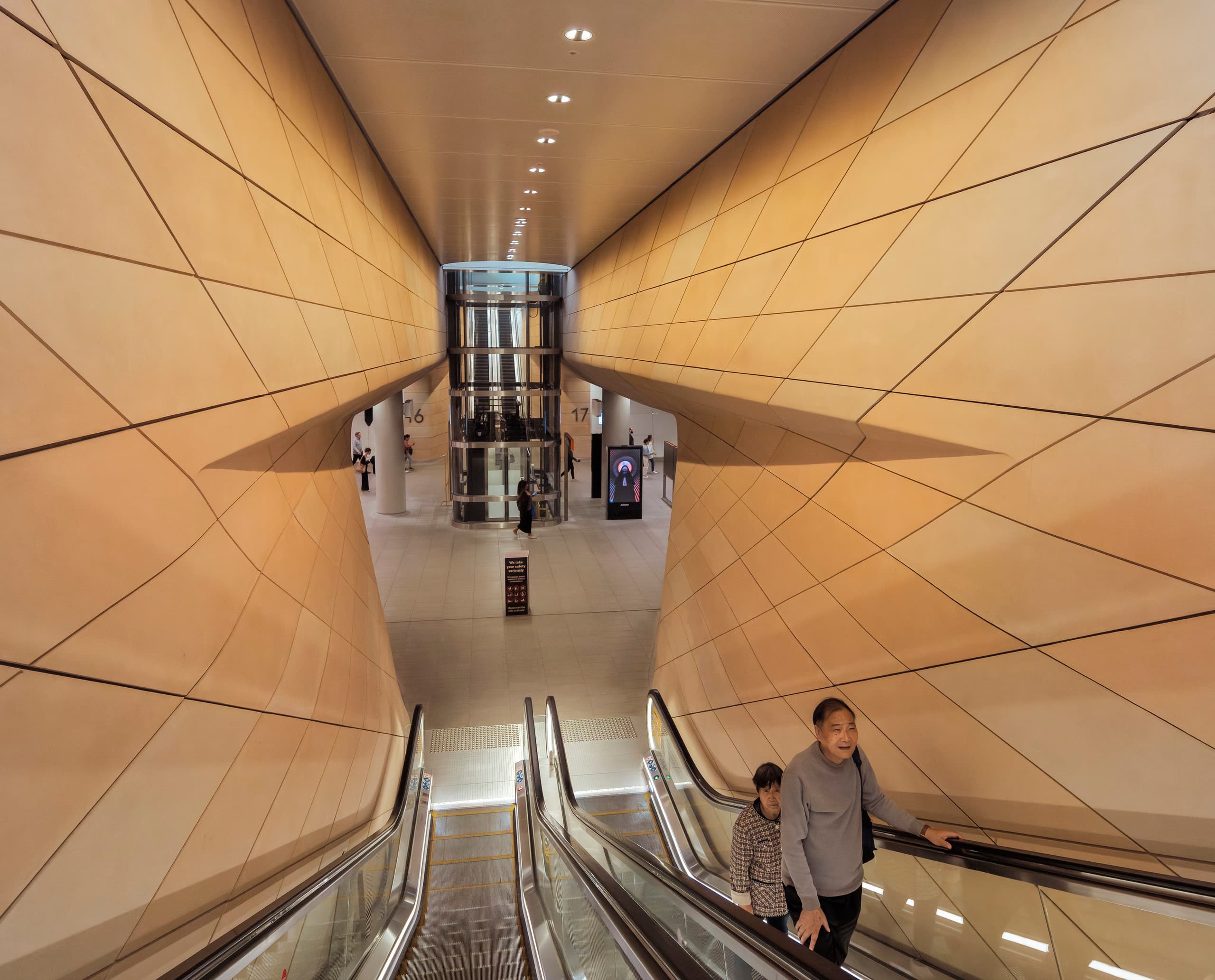 Personen auf der Rolltreppe in der Central Station Sydney mit ERCO Beleuchtung.