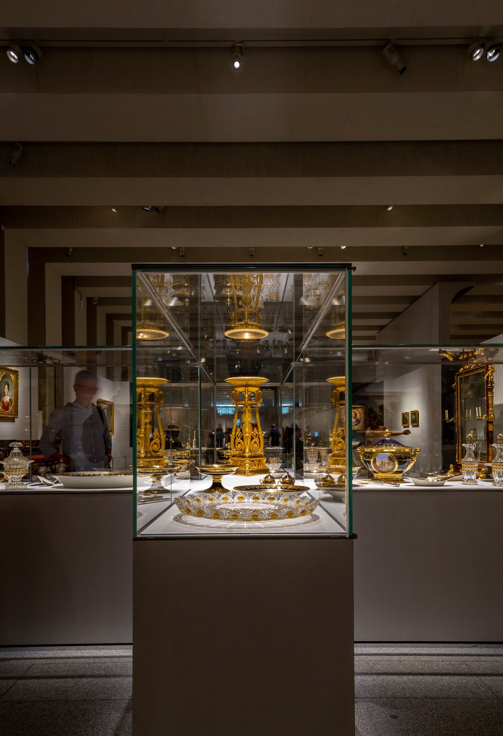 Beleuchtete Vitrine mit goldenen Artefakten in der Galería de las Colecciones Reales, Madrid.