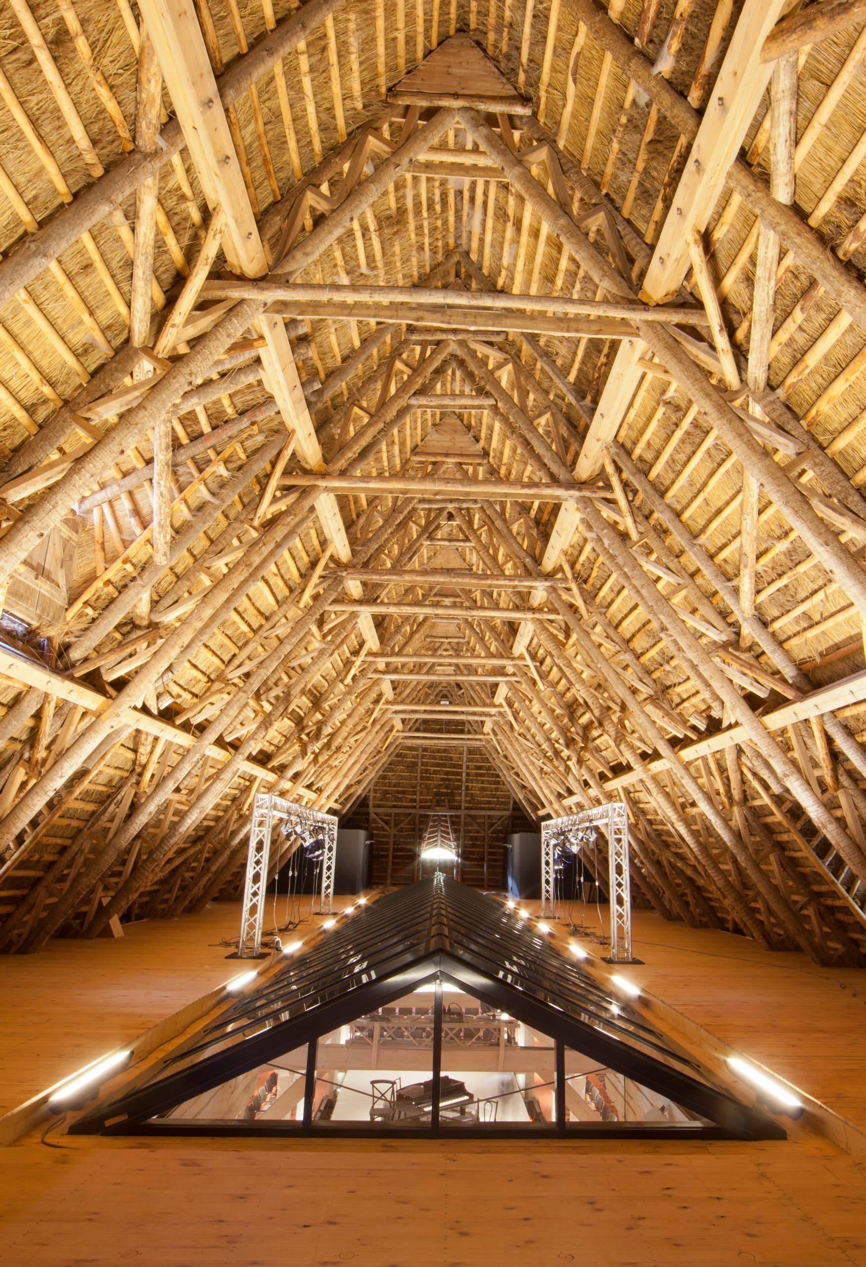 Holzbalkenkonstruktion im Weissenhaus Grand Village Resort & Spa mit ERCO Beleuchtung.