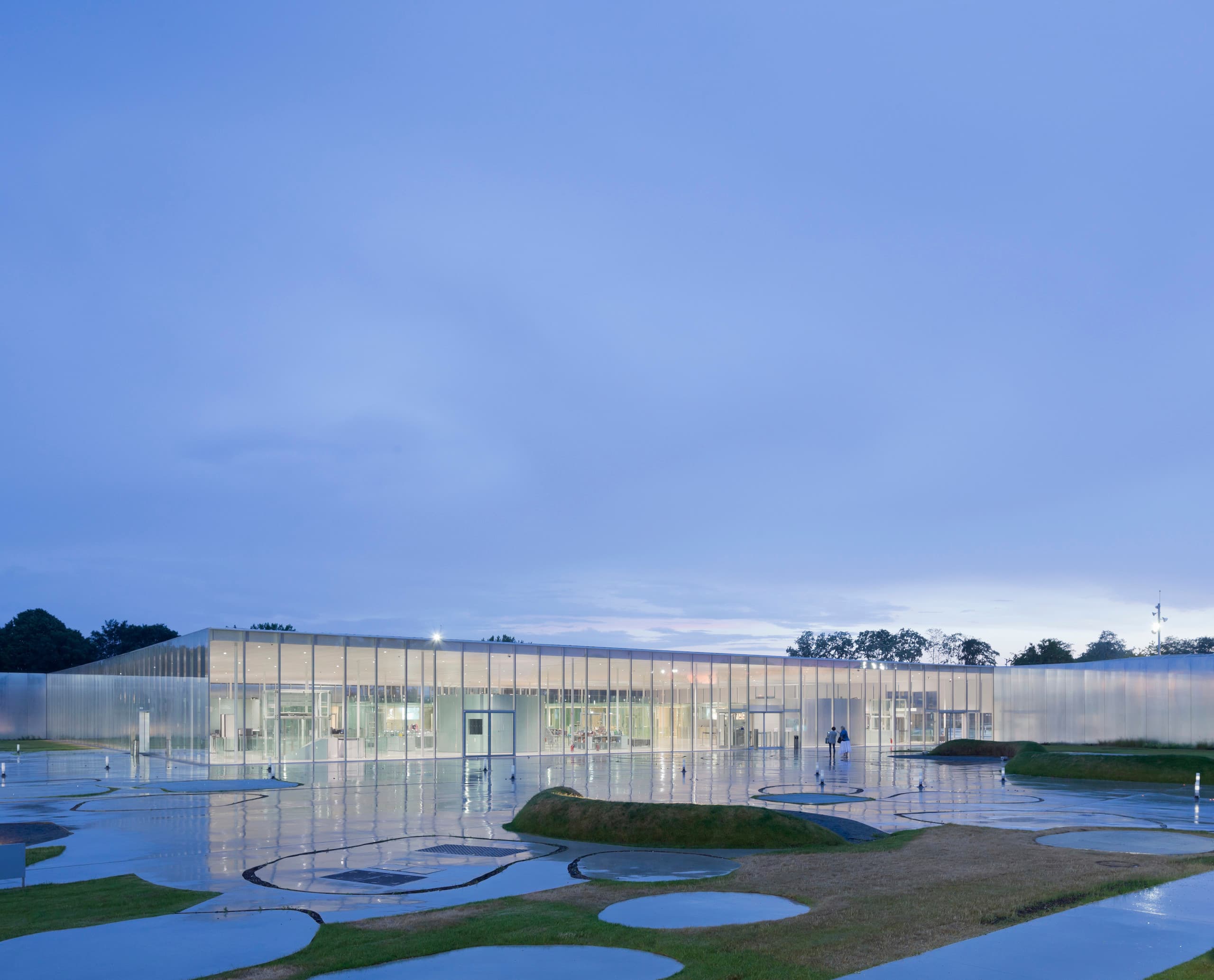 Louvre-Lens Museum bei Dämmerung, entworfen von SANAA, mit ERCO Beleuchtung für eine luxuriöse Transparenz.