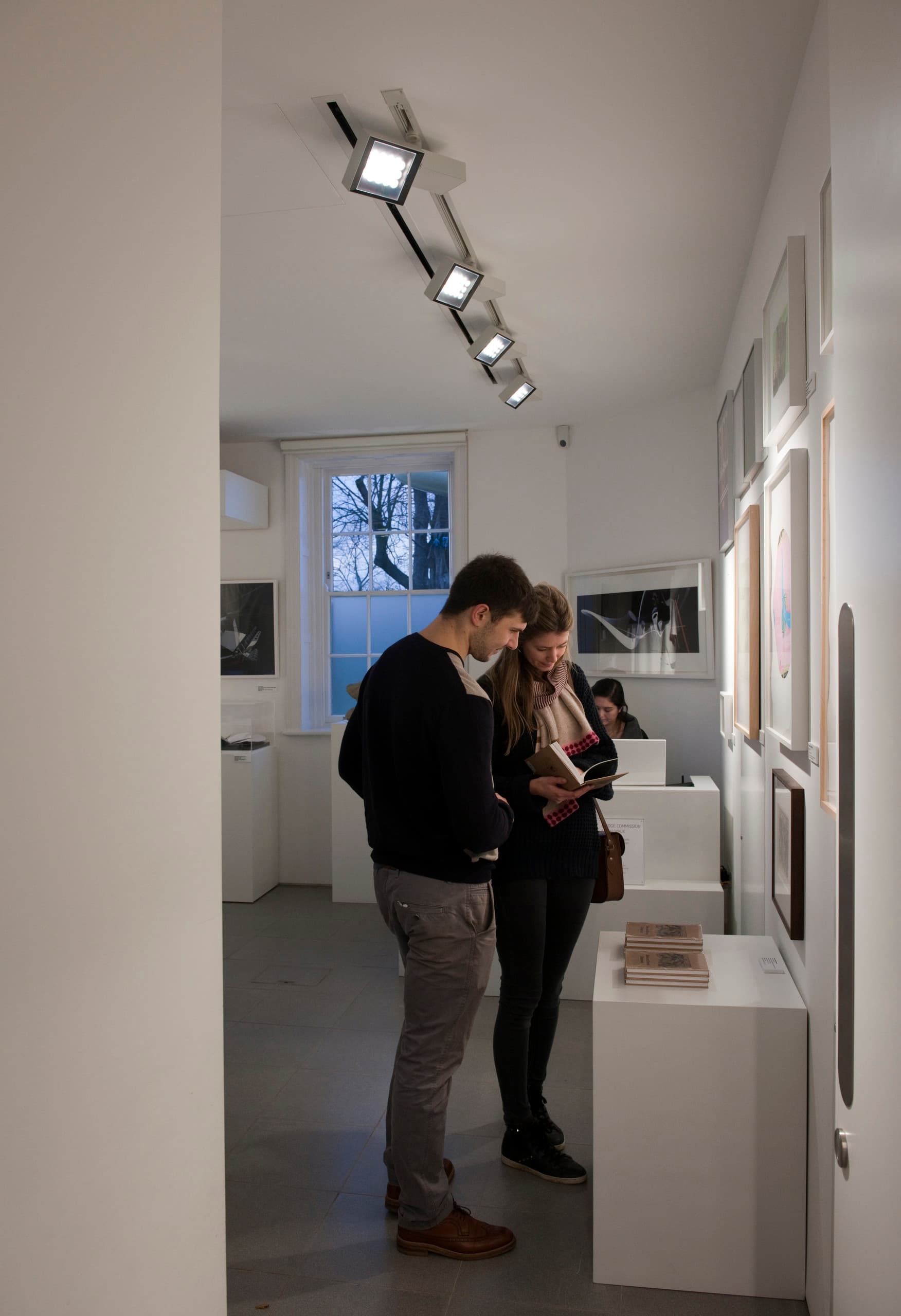 Besucher betrachten Kunst, beleuchtet von ERCO Opton Strahlern in der Serpentine Sackler Gallery.