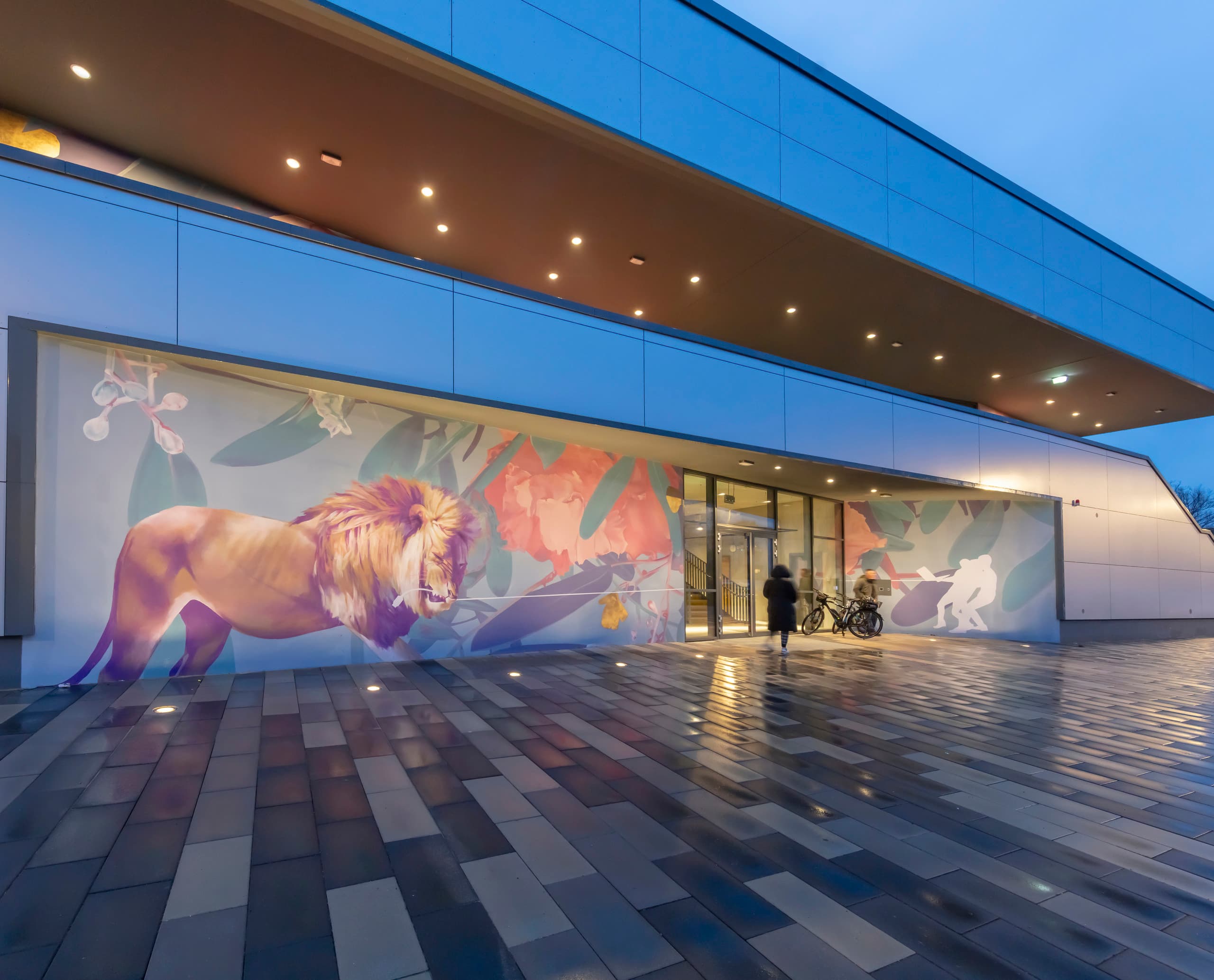 ERCO LED-Beleuchtung am Gymnasium Neustadt mit farbenfroher Fassadenkunst.