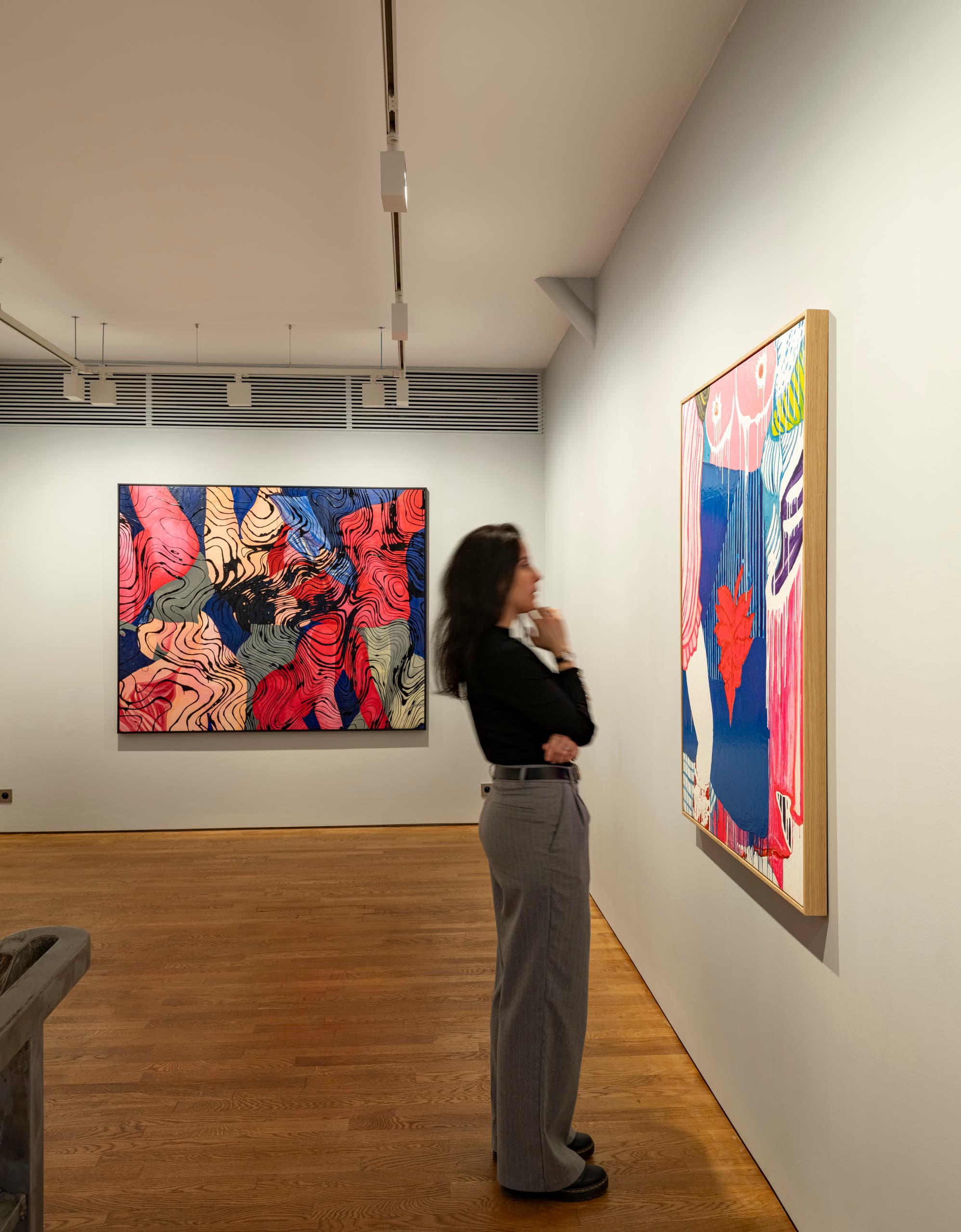 Frau betrachtet Kunst in der Lilia Ben Salah Galerie, beleuchtet mit ERCO LED-Strahlern.