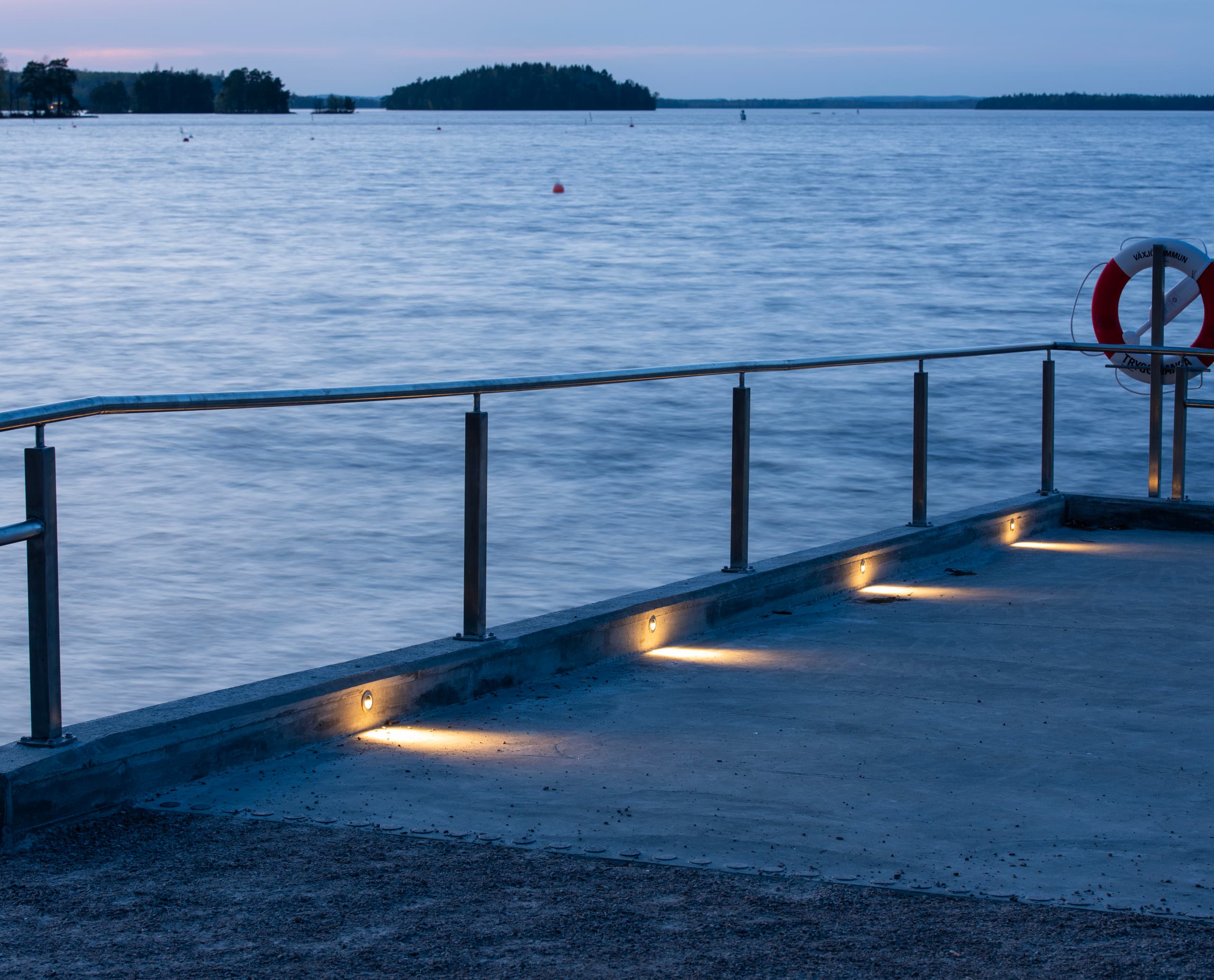 Tesis Bodeneinbauleuchten am Evedal-See in Växjö, die abends für Orientierung sorgen.