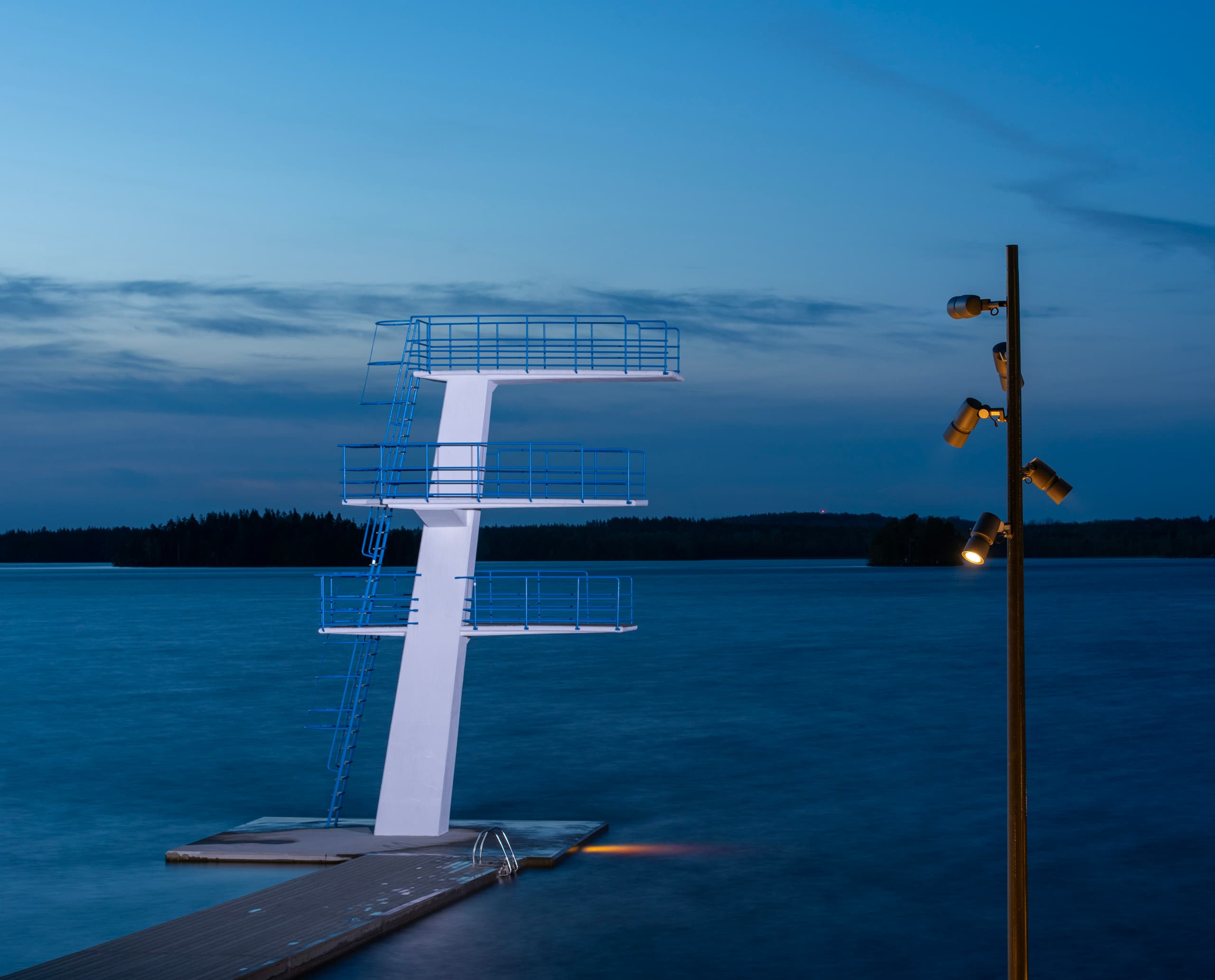 Beleuchteter Sprungturm im Evedal Schwimmbad, Växjö, mit ERCO LED-Außenbeleuchtung für stimmungsvolles Licht.