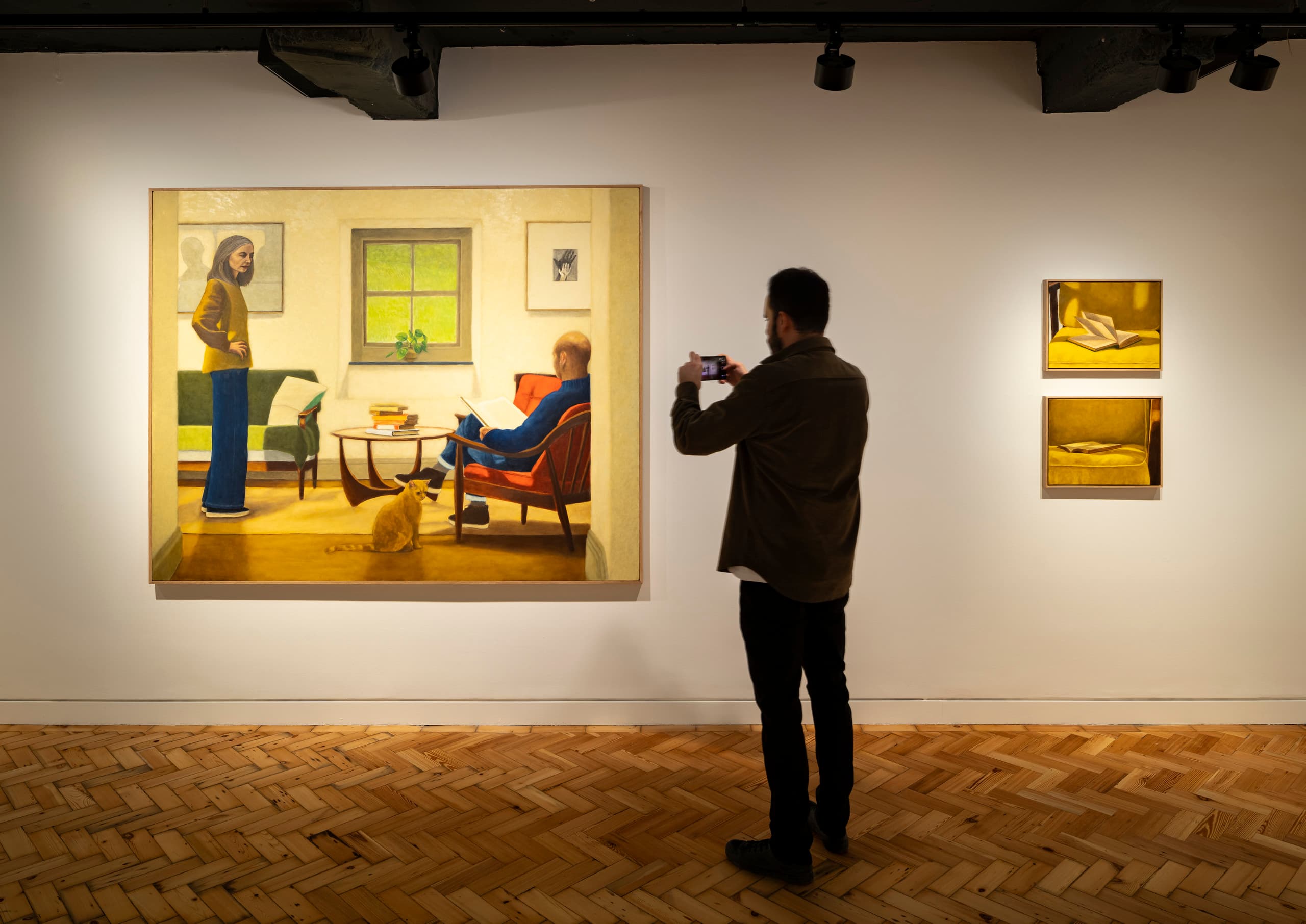 Galeriebeleuchtung: Besucher fotografiert Kunstwerk unter ERCO-Beleuchtung.