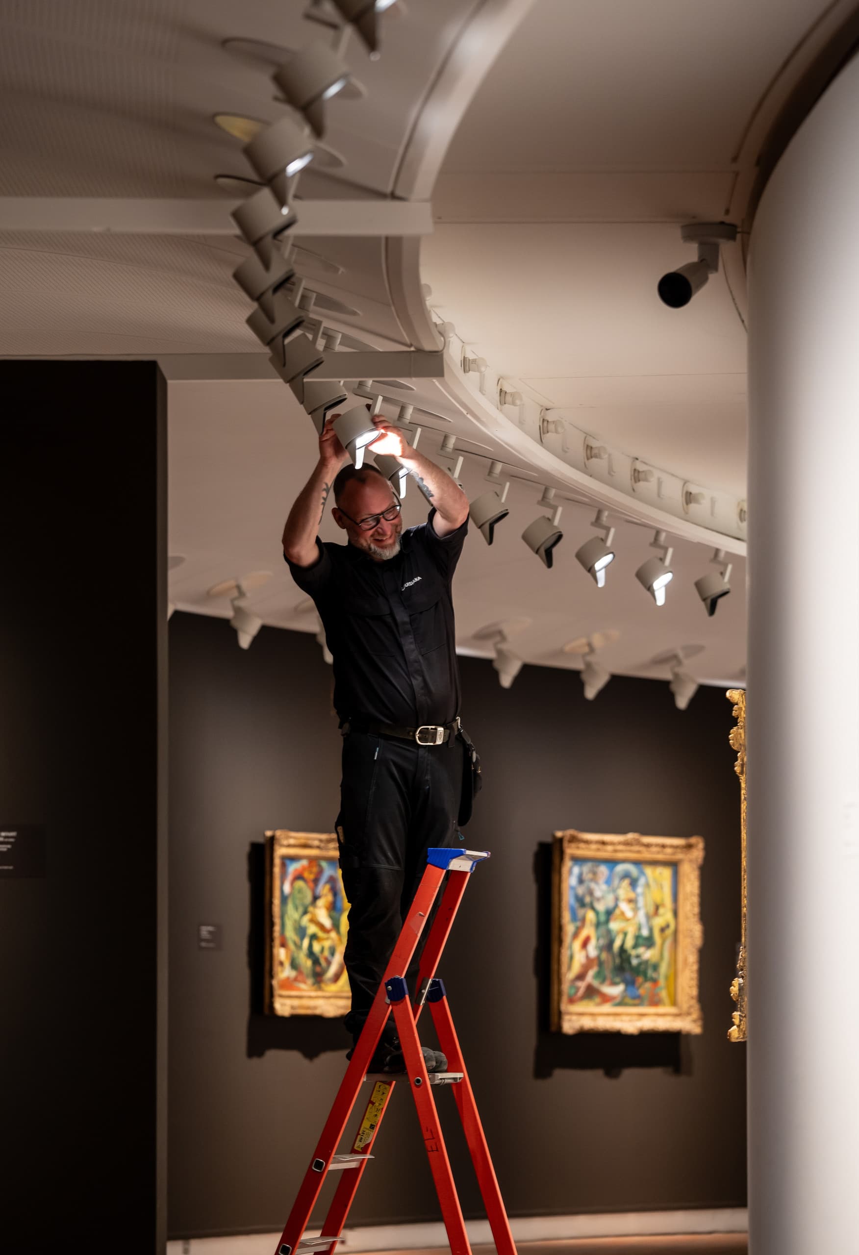 Ein Elektriker justiert einen ERCO Parscan LED-Strahler im Louisiana Museum, um Kunstwerke optimal zu beleuchten.