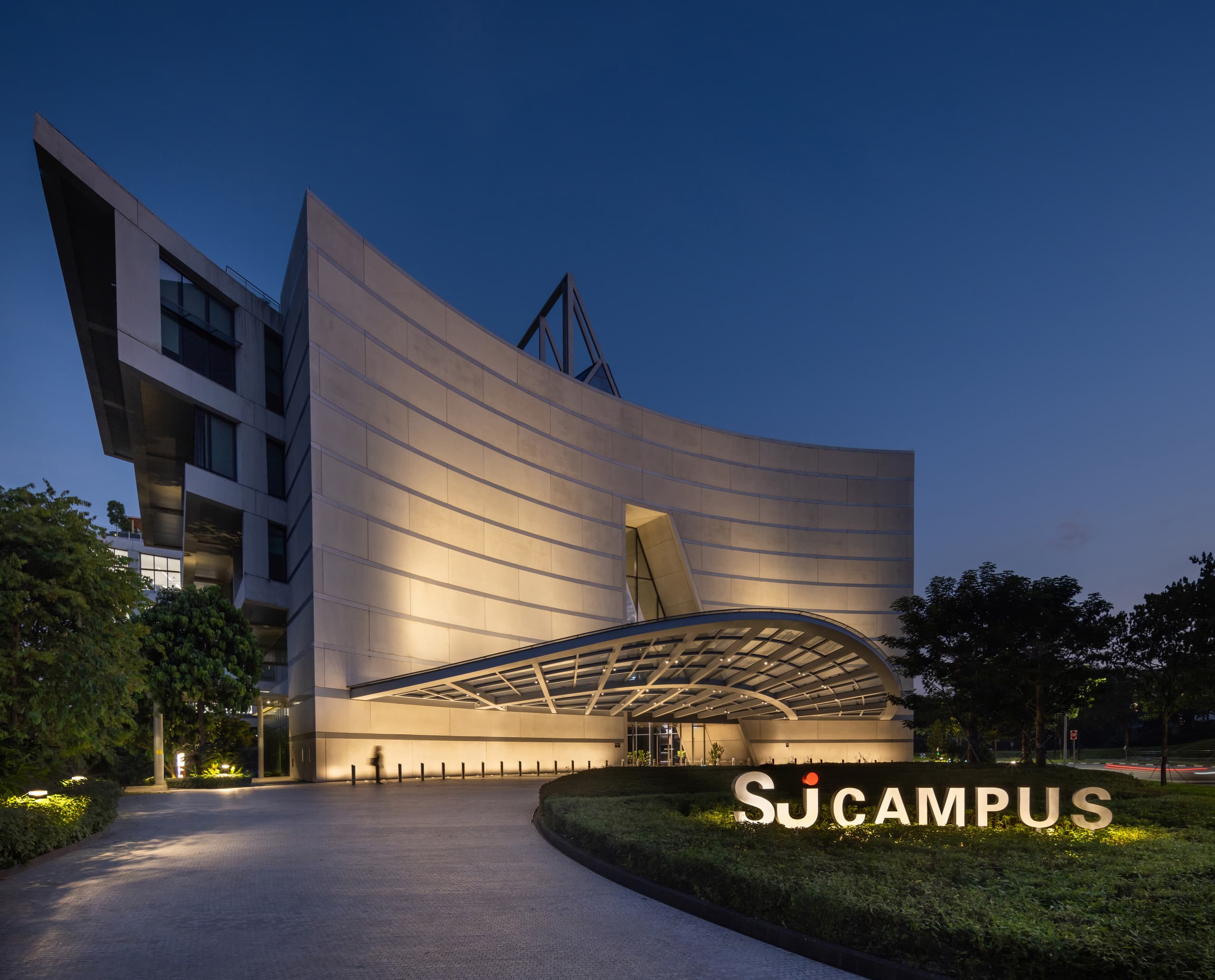 Beleuchtetes Surbana Jurong Campusgebäude in Singapur mit ERCO LED-Beleuchtung.