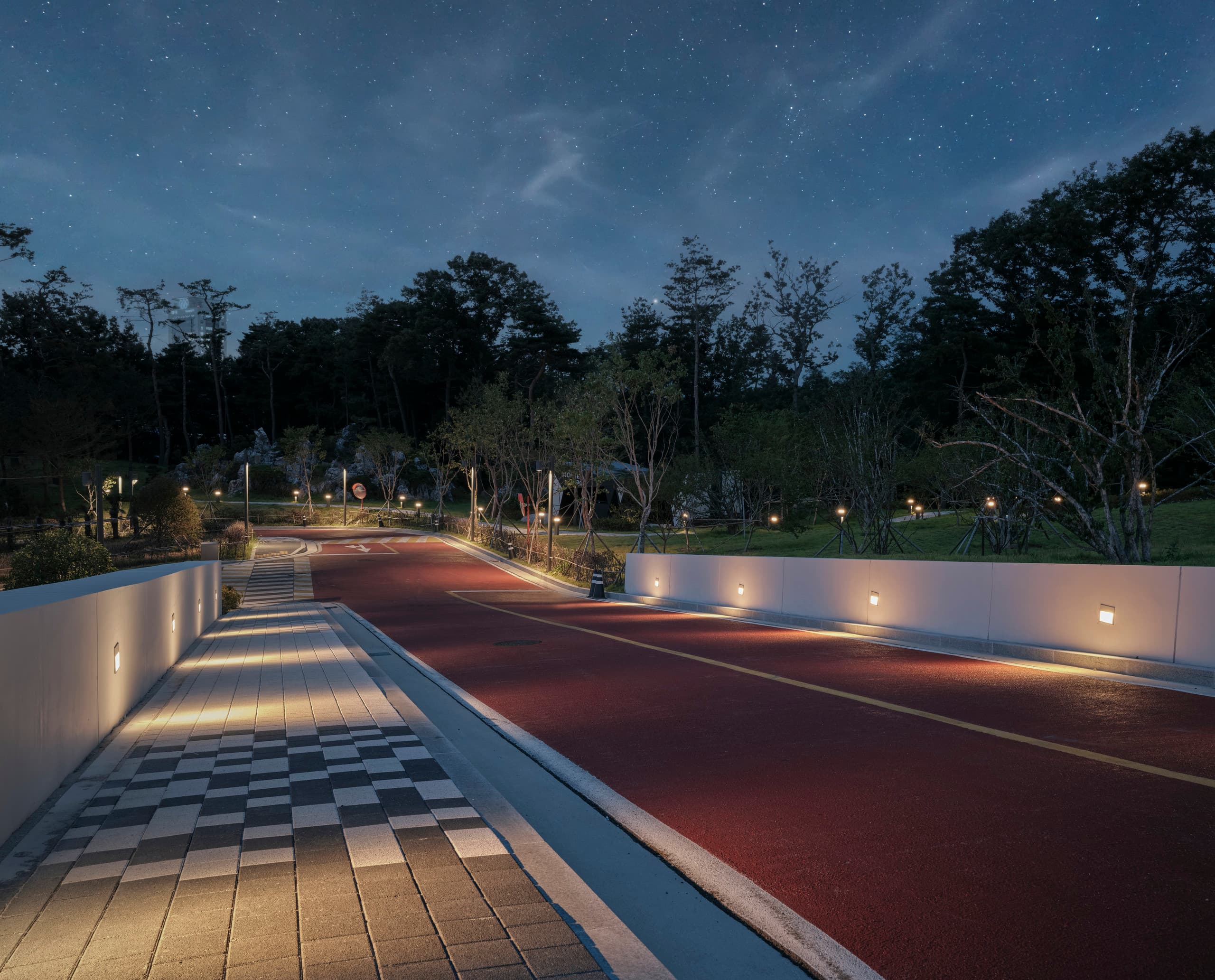 ERCO Lightmark Bodenstrahler beleuchten Wege im Sorol Art Museum bei Nacht und bewahren den dunklen Himmel.