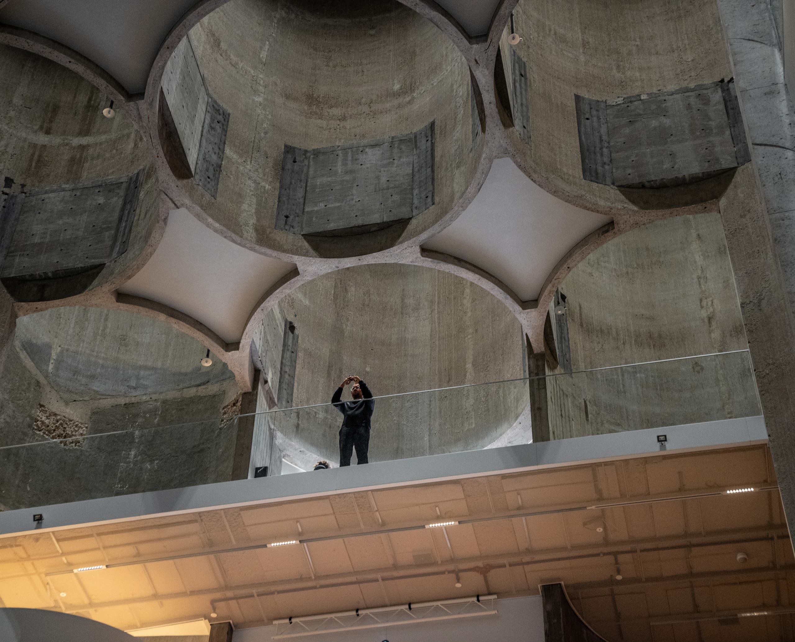 Kunstsilo Kristiansand: Besucher bewundert die Architektur mit ERCO Beleuchtung.
