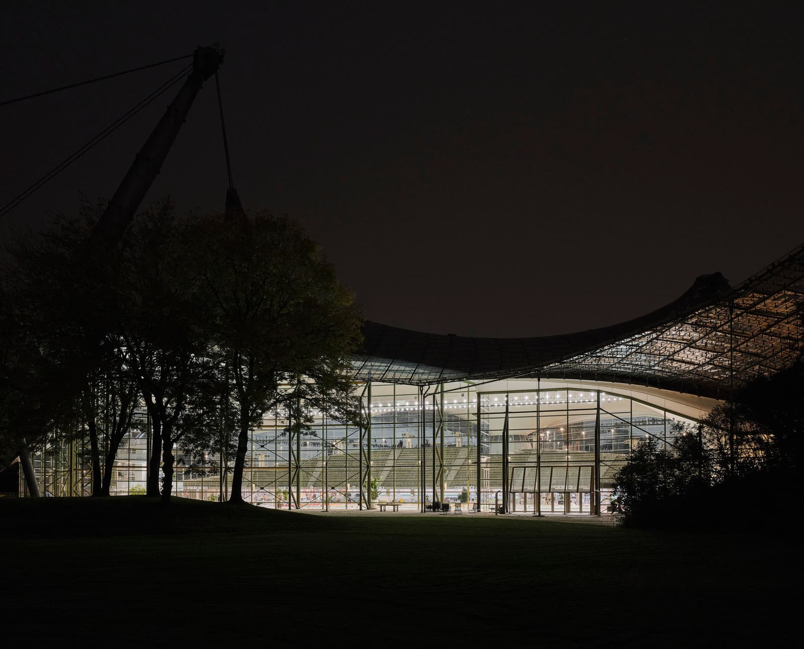 Nachts beleuchtetes Schwimmzentrum im Olympiapark München mit ERCO LED-Beleuchtung.