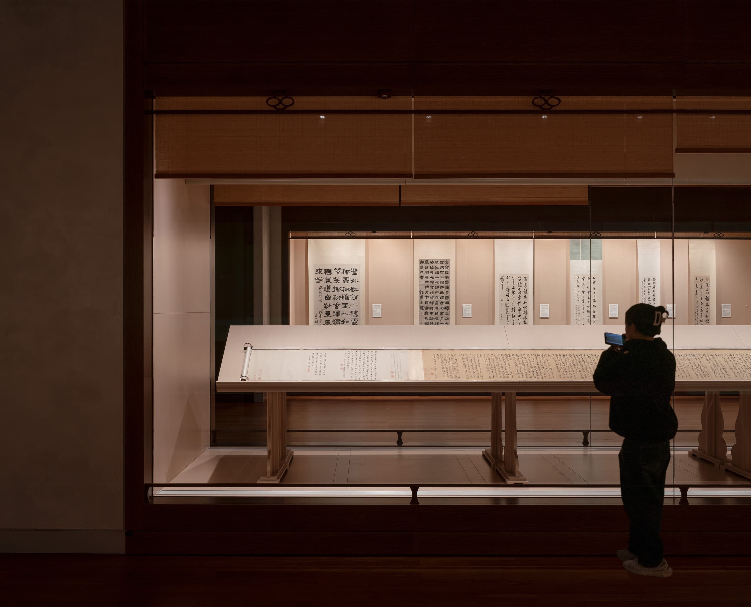 Besucher im Shanghai Museum East betrachtet Kalligrafie, beleuchtet mit ERCO Strahlern für optimale Konservierung.